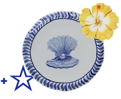A decorative plate with a blue and white shell design and a yellow hibiscus flower attached to the side.