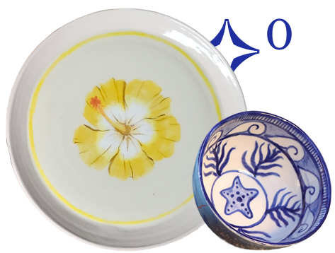 A ceramic plate with a yellow flower design and a small blue bowl with a starfish and coral pattern.