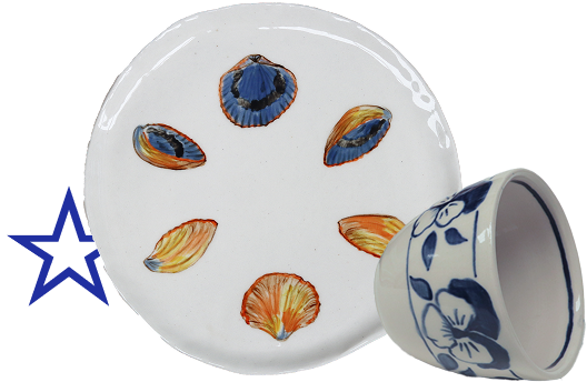 A white ceramic plate with six painted blue, orange, and yellow shells and a white coffee cup with blue floral designs.