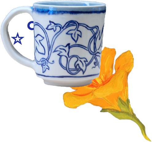 A blue and white ceramic mug with floral patterns next to an orange flower.