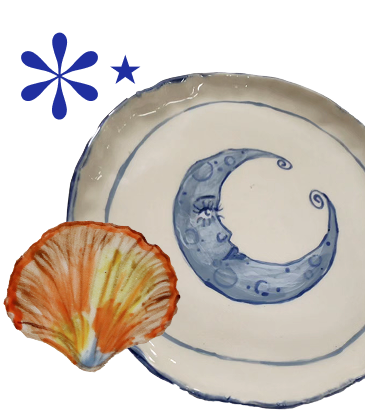 A ceramic plate with a blue crescent moon design and a watercolor flower in orange and yellow hues.