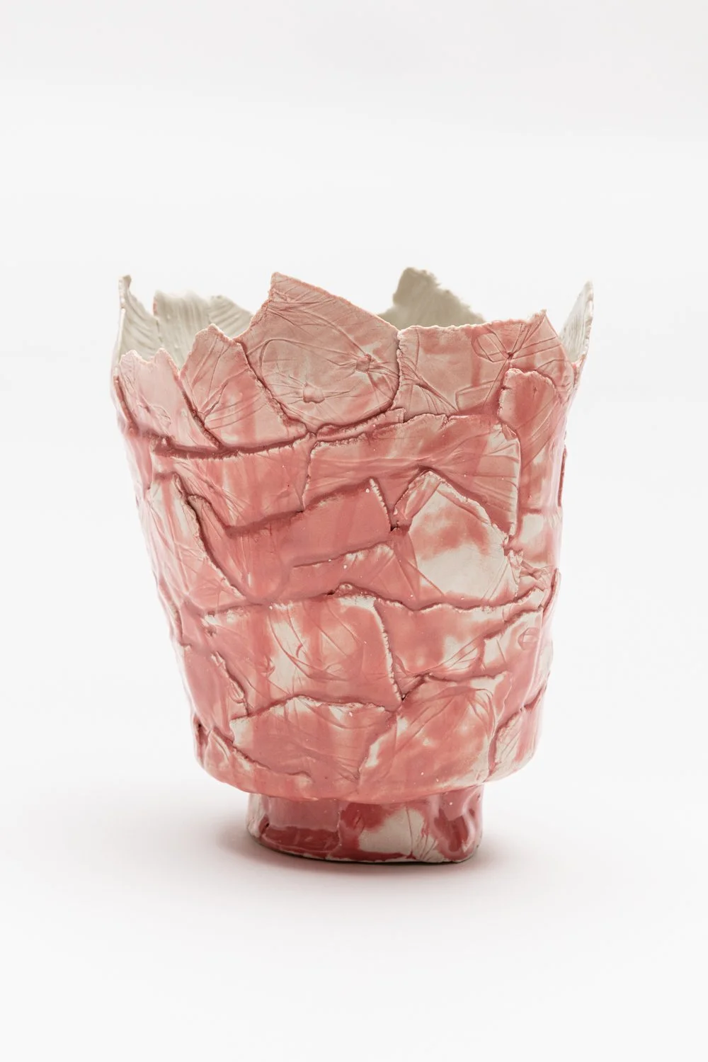 Ceramic vase with a pink and white marbled pattern and textured, crumpled surface.