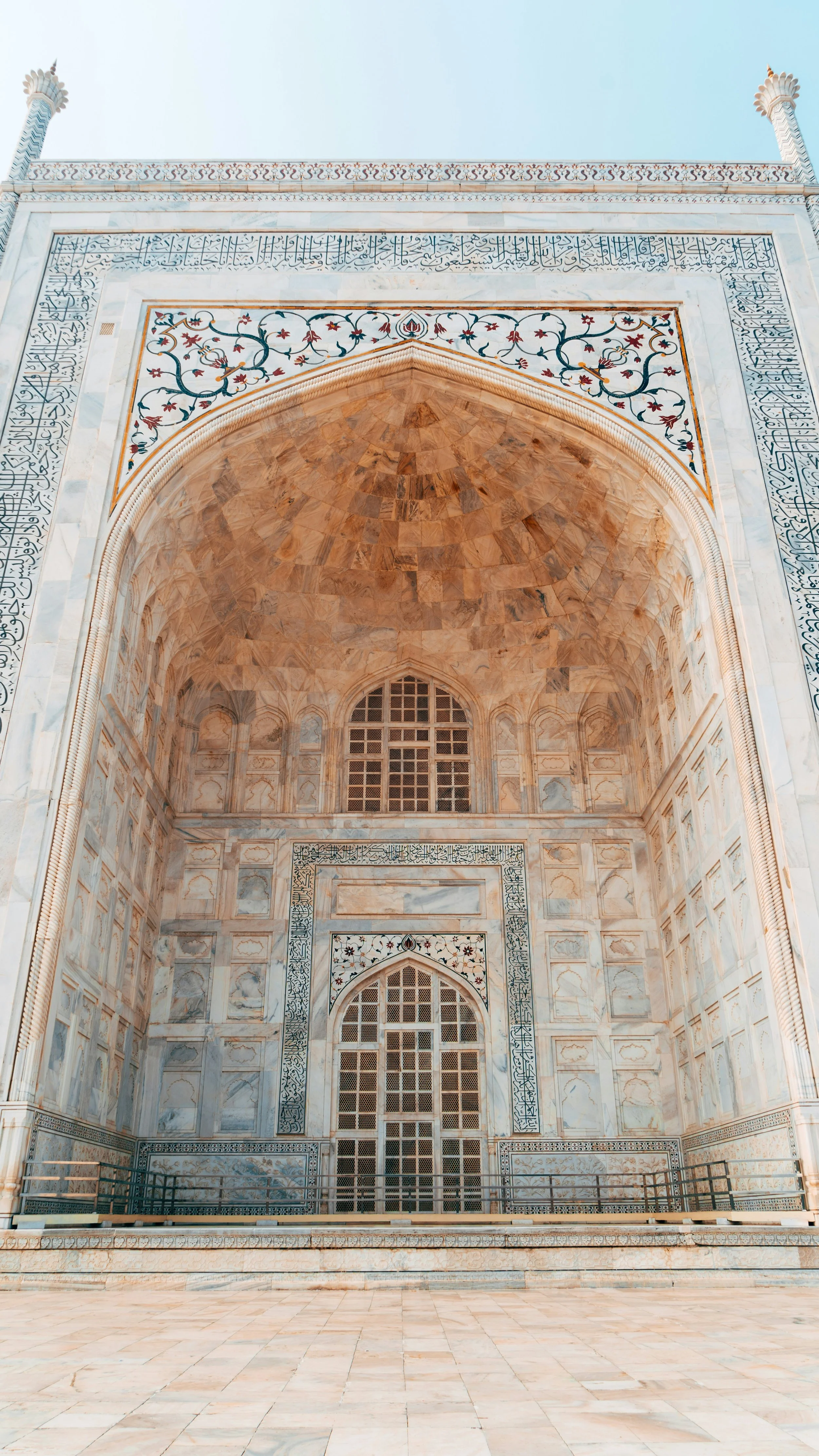 Close-up view of the ornate marble interior of the Taj Mahal with intricate tile work and arches.