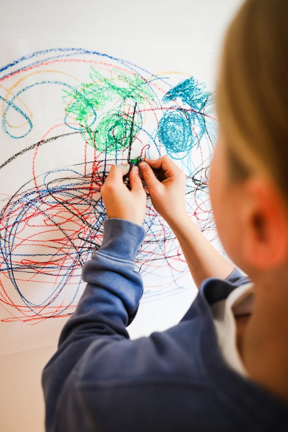 Older child drawing with pastels during the After-School Art Hive program in Edmonton.