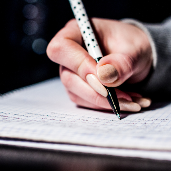 Close-up of hand writing with patterned pen – mindful journaling and reflective creative practice.