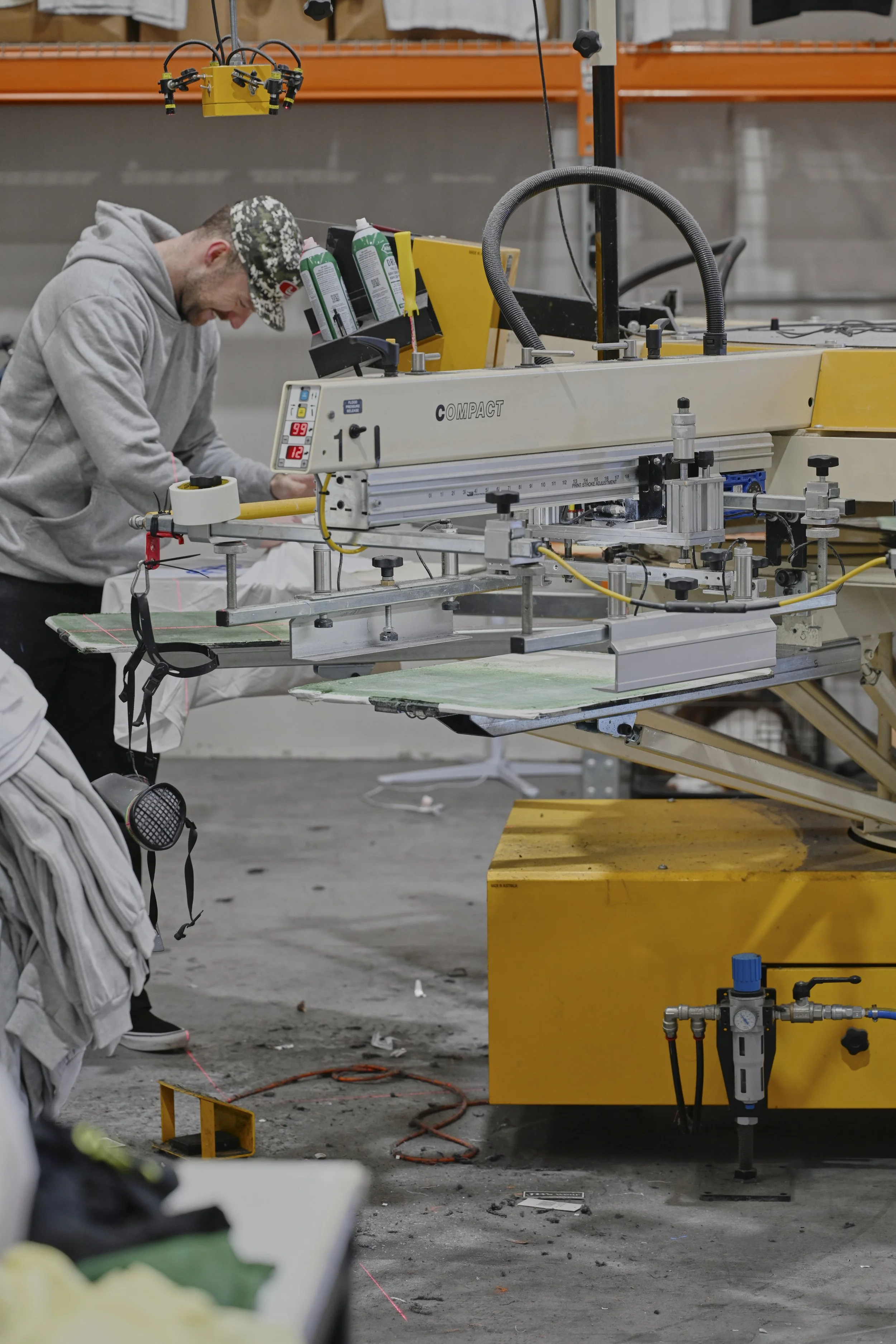A technician working in an industrial warehouse or manufacturing facility, operating machinery with various tools and equipment.