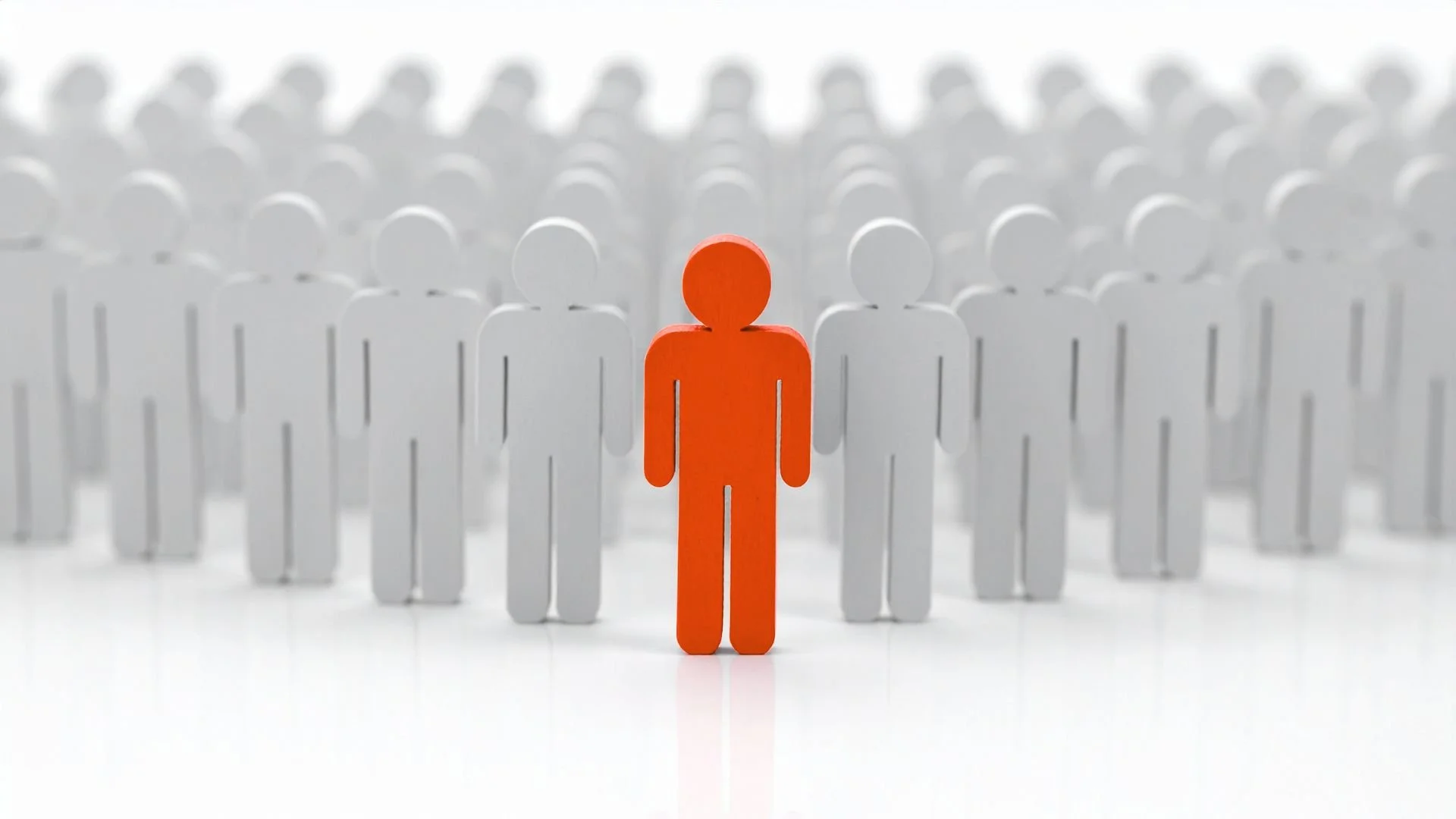 A red human figure standing in front of numerous white human figures, symbolizing individuality or leadership among a crowd.