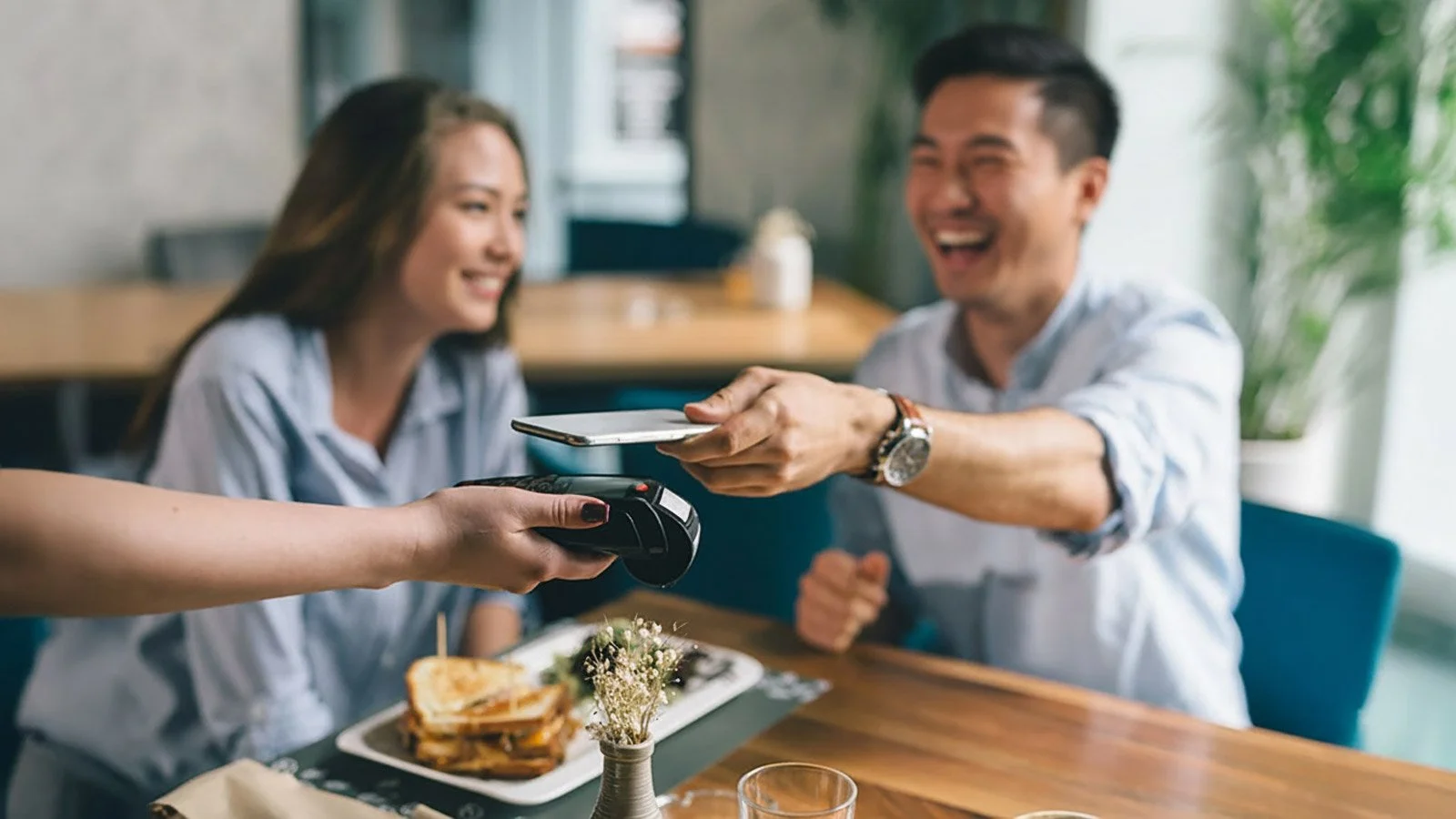 Asian couple paying a bill in restaurant
