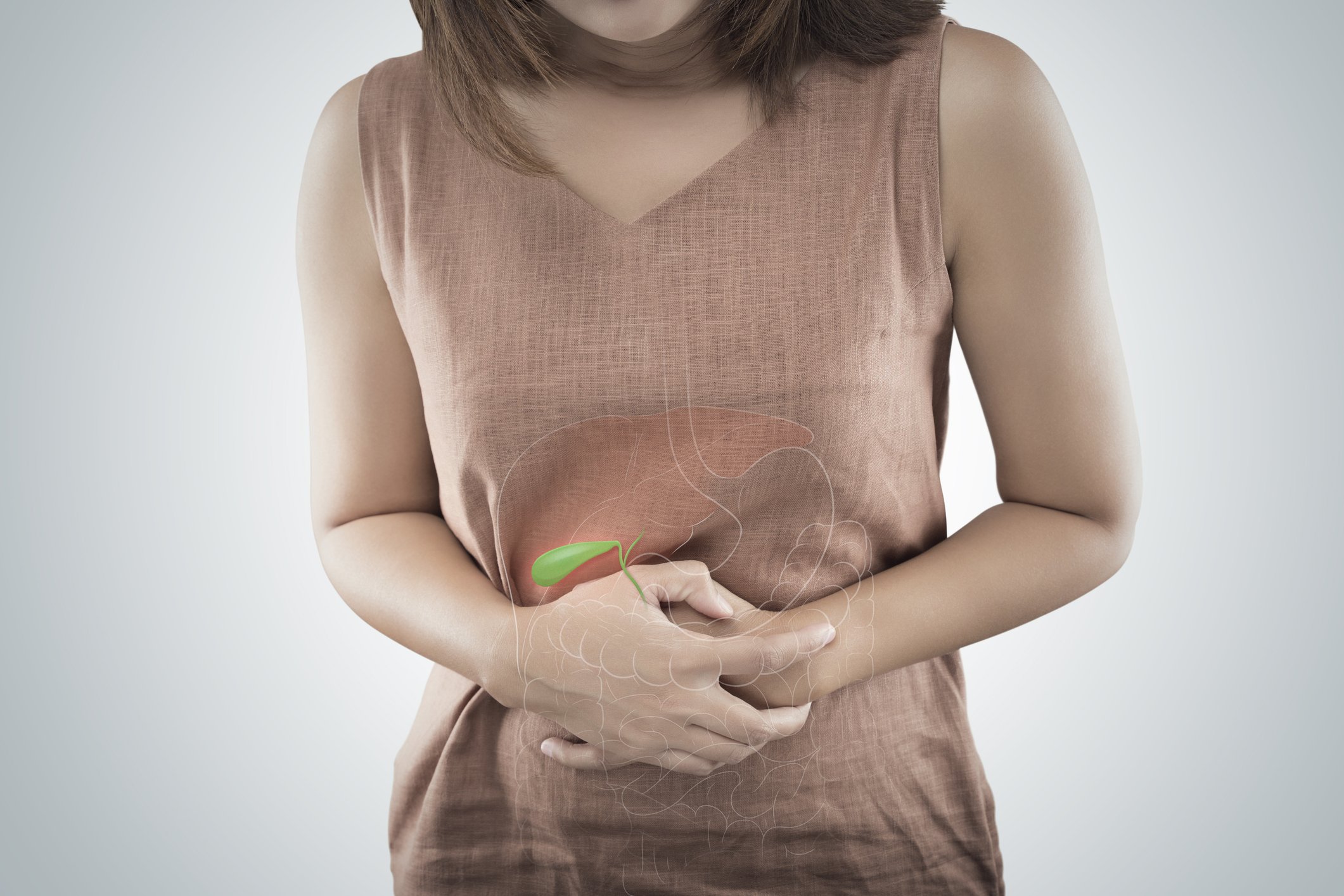 A woman wearing a sleeveless brown top holding her stomach with a digital overlay of a gallbladder highlighted in green.