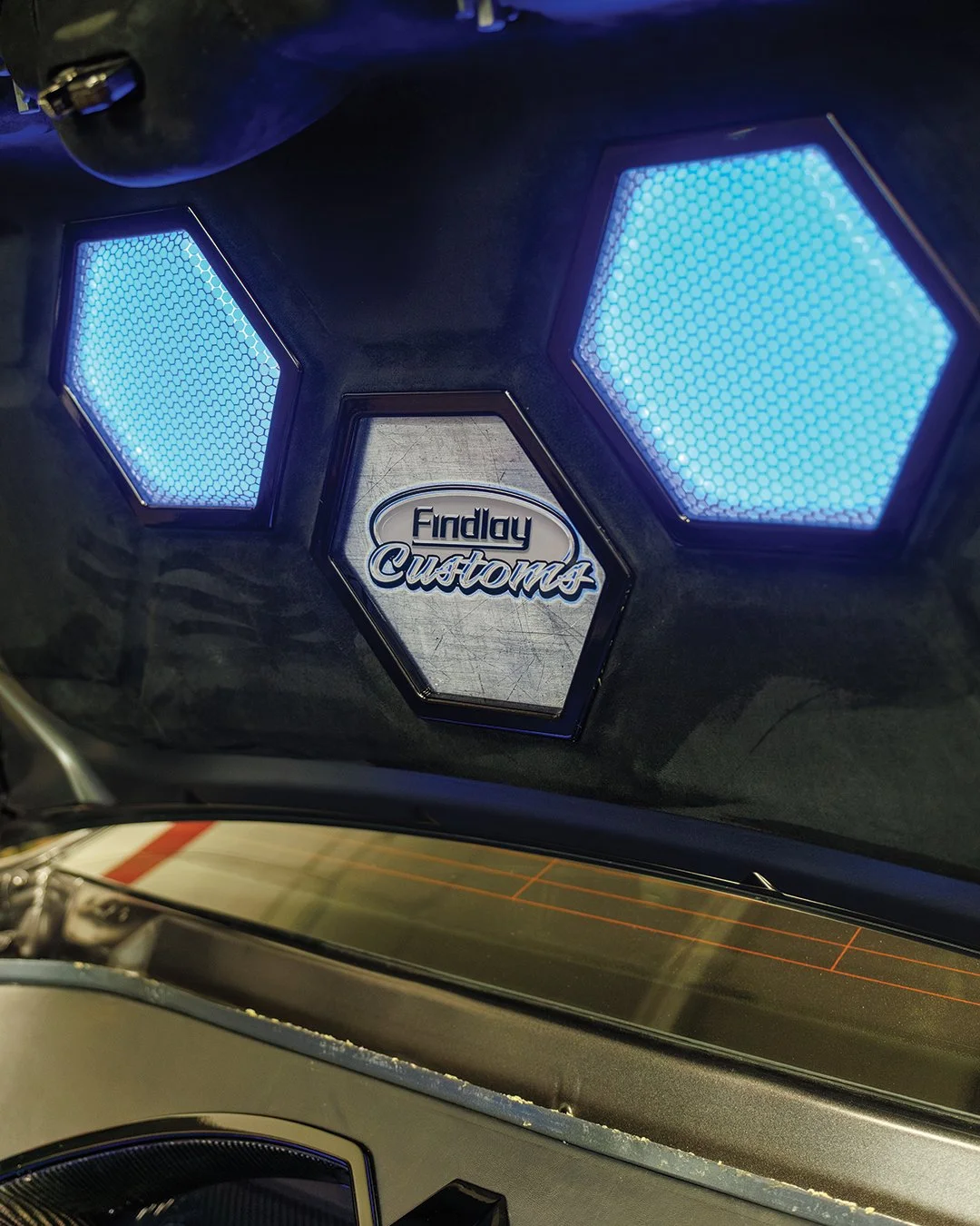 A picture of a car rear trunk custom fitted with speakers and led lights for show.