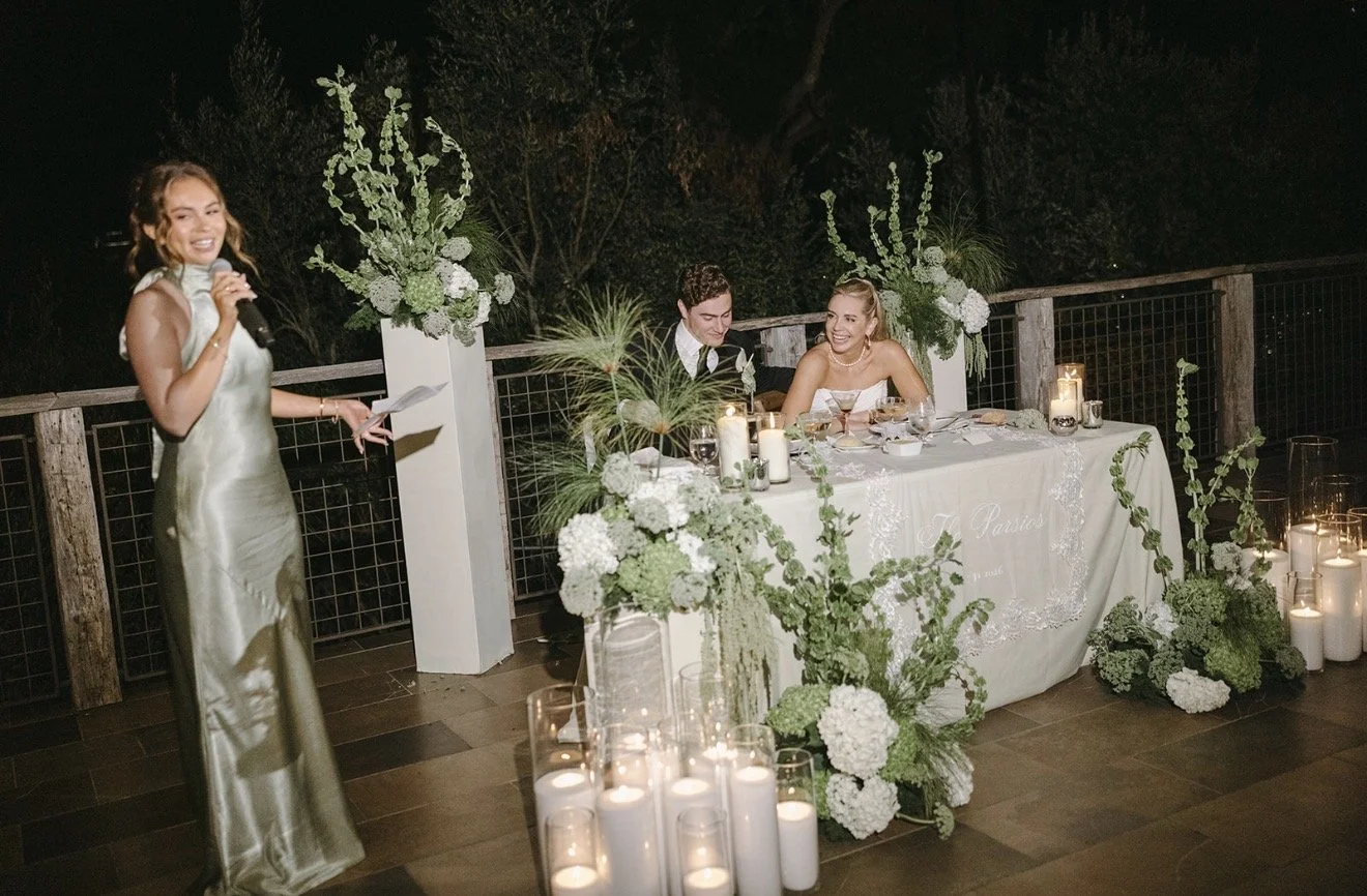 Candles arranged in rows in front of a dark, curved ceiling or wall with a textured surface.