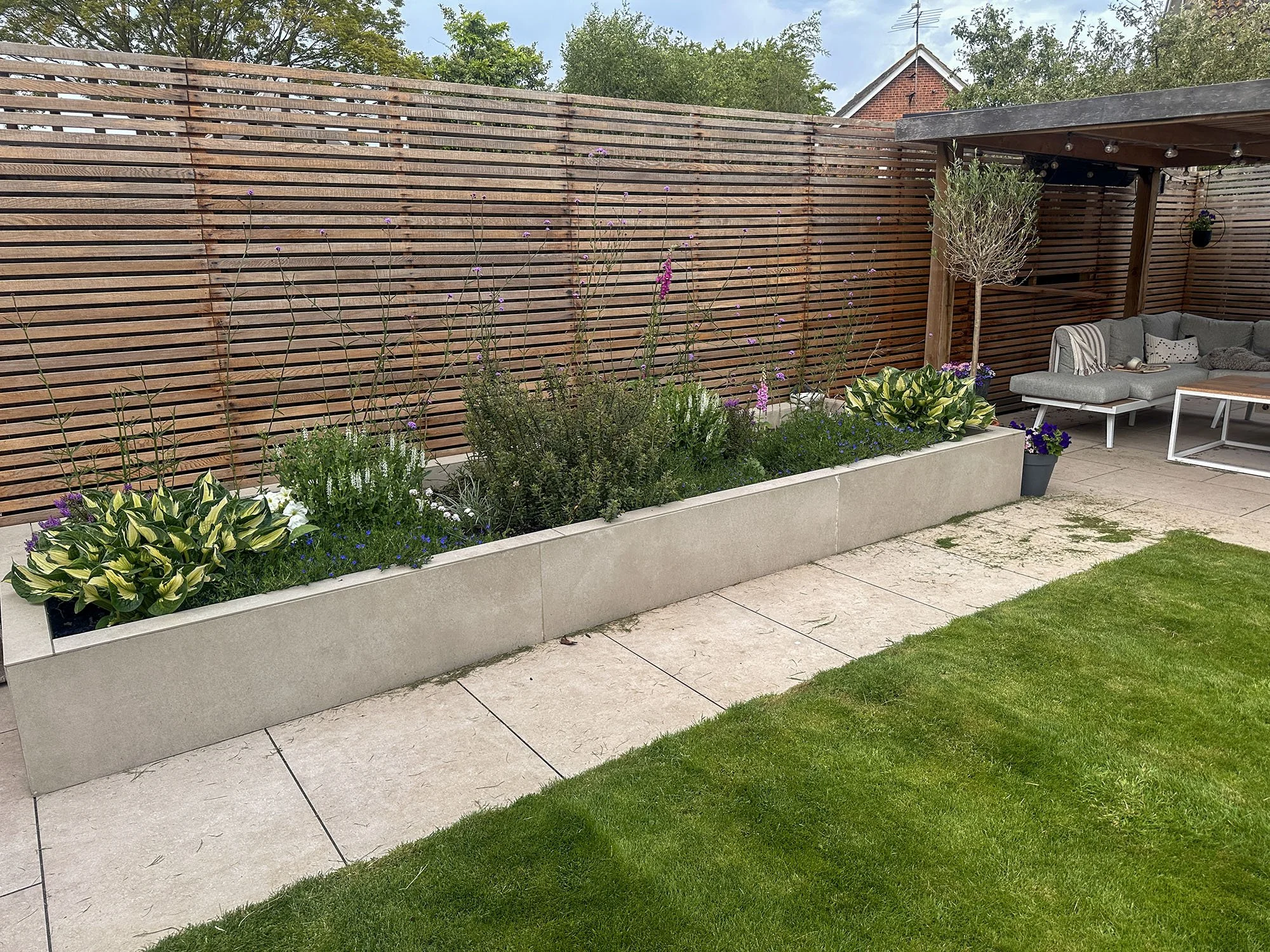 Finished garden with paving, raised flower bed, lawn and timber screening