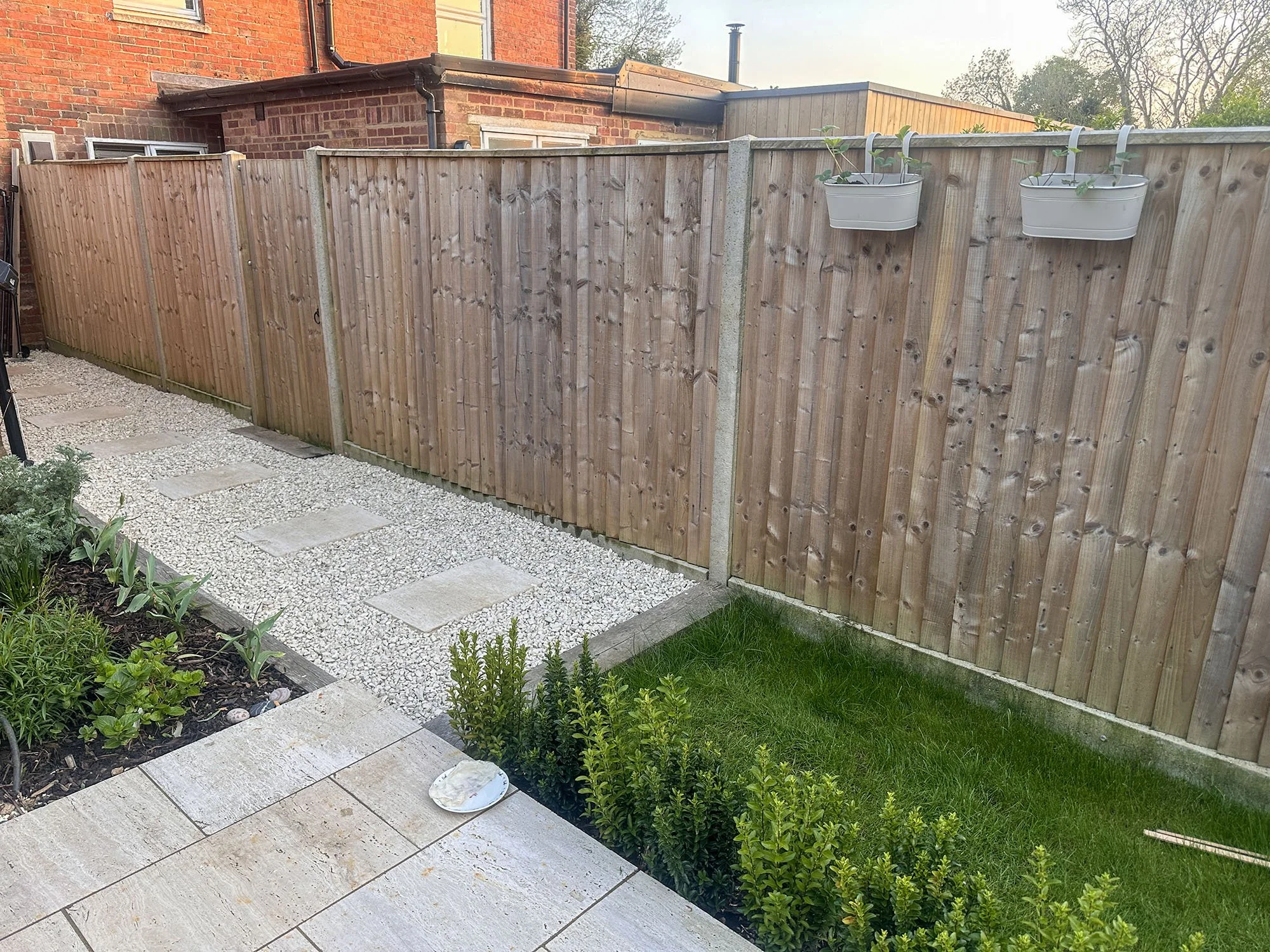 Timber garden fence beside a gravel path and lawn