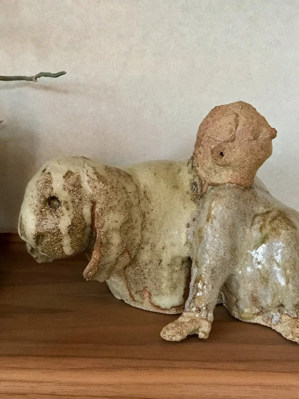 jente som lener seg mot en kanin, kaninvenn, laget i steingodsleire, lys glasur