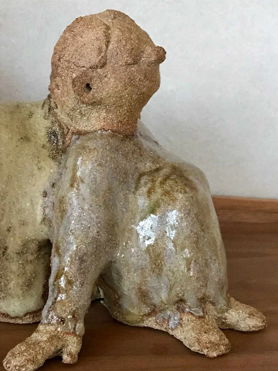 jente som lener seg mot en kanin, kaninvenn, laget i steingodsleire, lys glasur, detalj fra siden