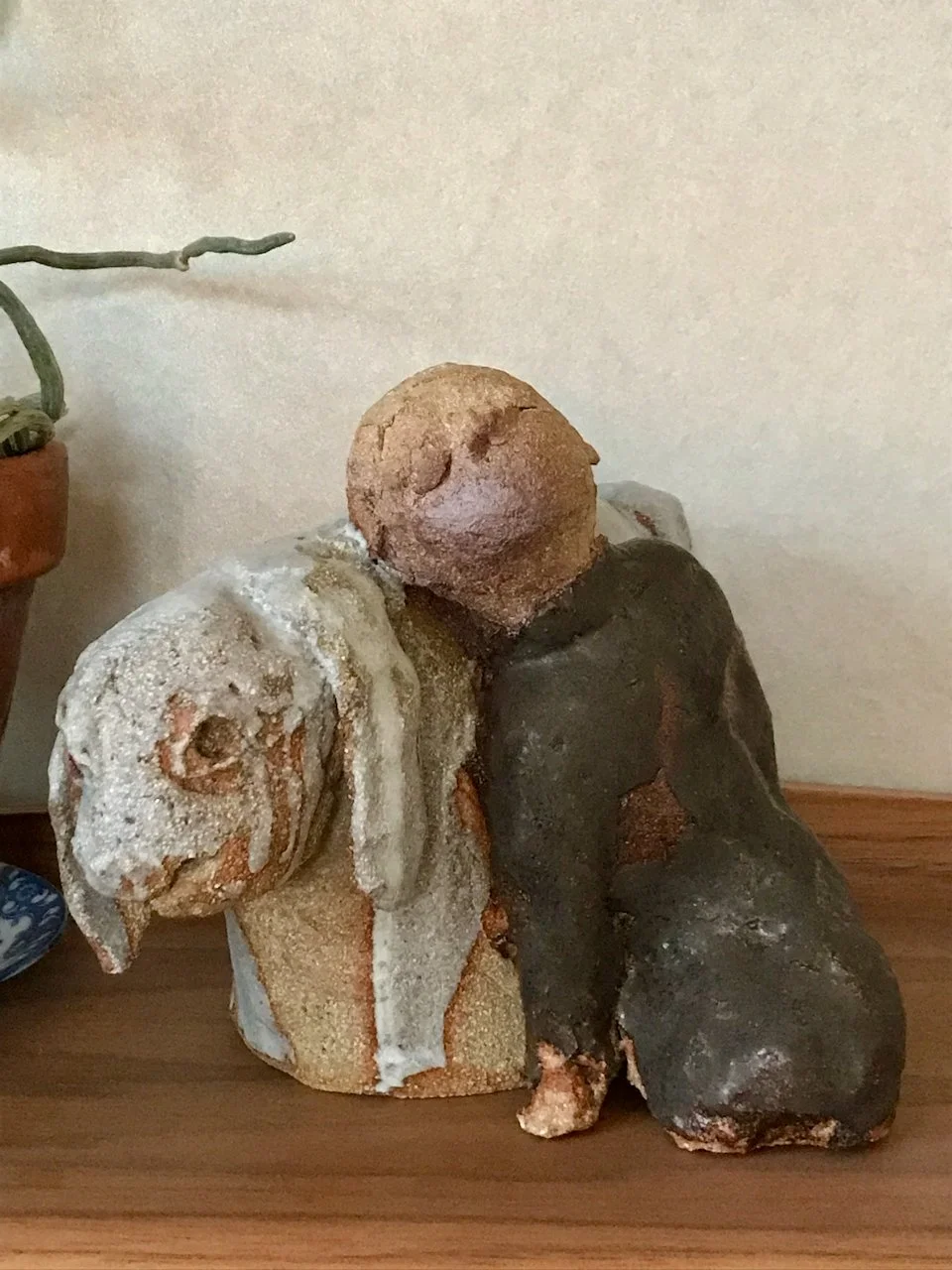 jente og kanin i steingodsleire, jentefigur i brun glasur, kanin i lysgrå glasur, står på hylle