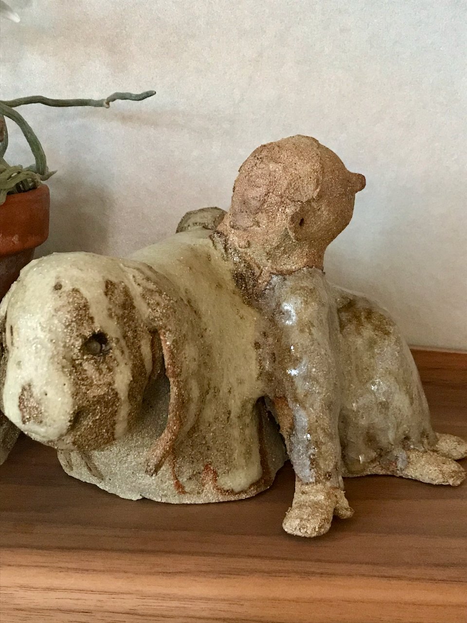 jente som lener seg mot en kanin, kaninvenn, laget i steingodsleire, lys glasur, fra siden