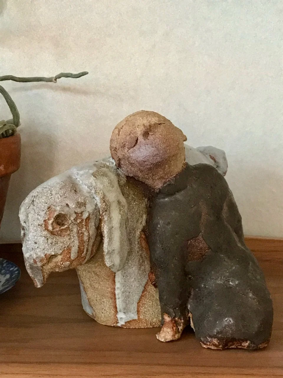 jente og kanin i steingodsleire, jentefigur i brun glasur, kanin i lysgrå glasur, står på hylle