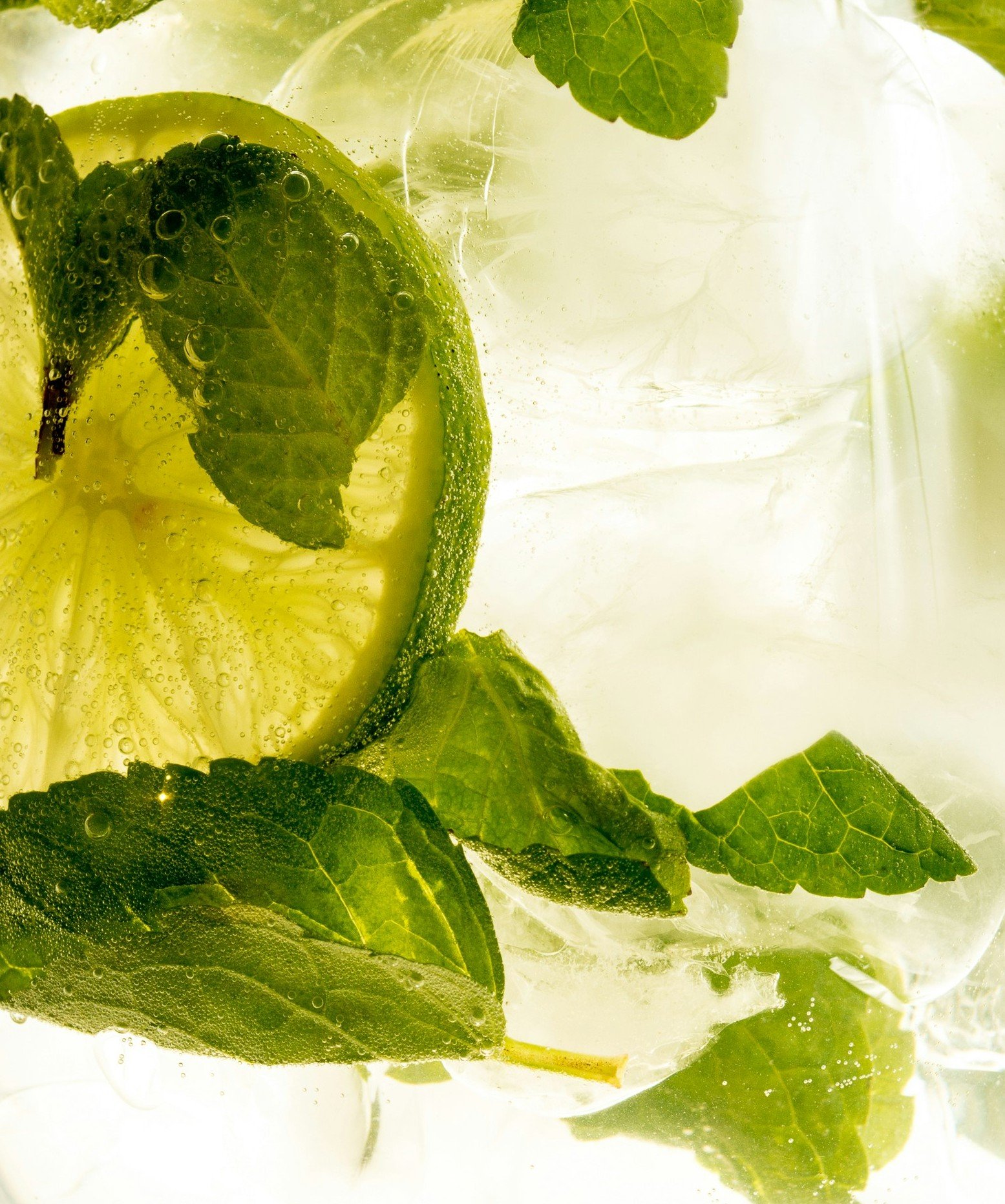Close-up of lime and mint in water with ice cubes, symbolising vitality and renewal after transforming limiting beliefs with PSYCH-K®