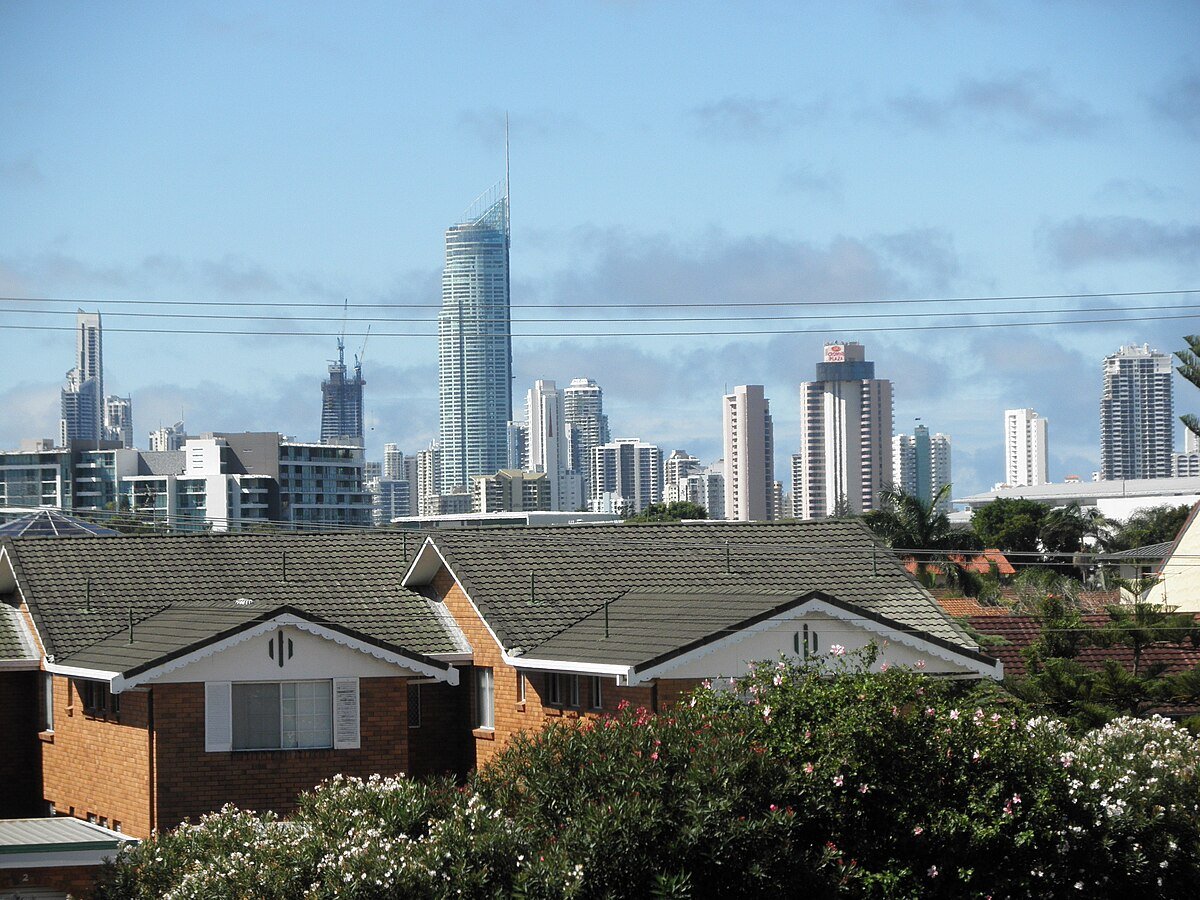 Gold Coast suburb housing with Surfers Paradise skyline, helpful context for rent vs buy decisions for New Zealand movers