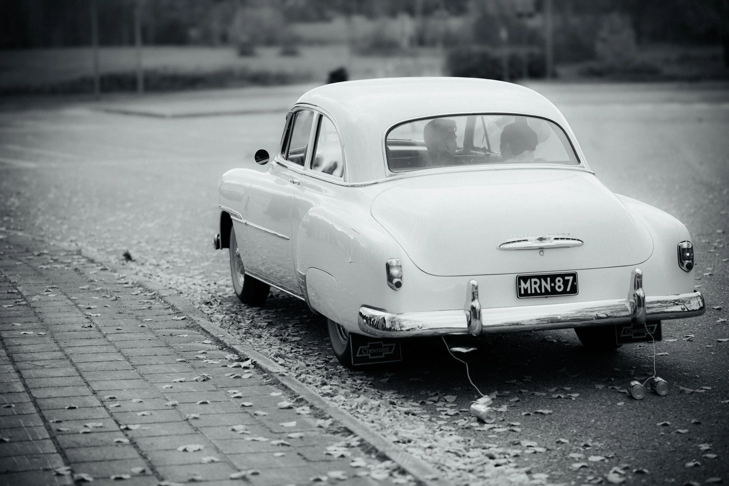 Hääpari hääautossa, mustavalkoinen kuva