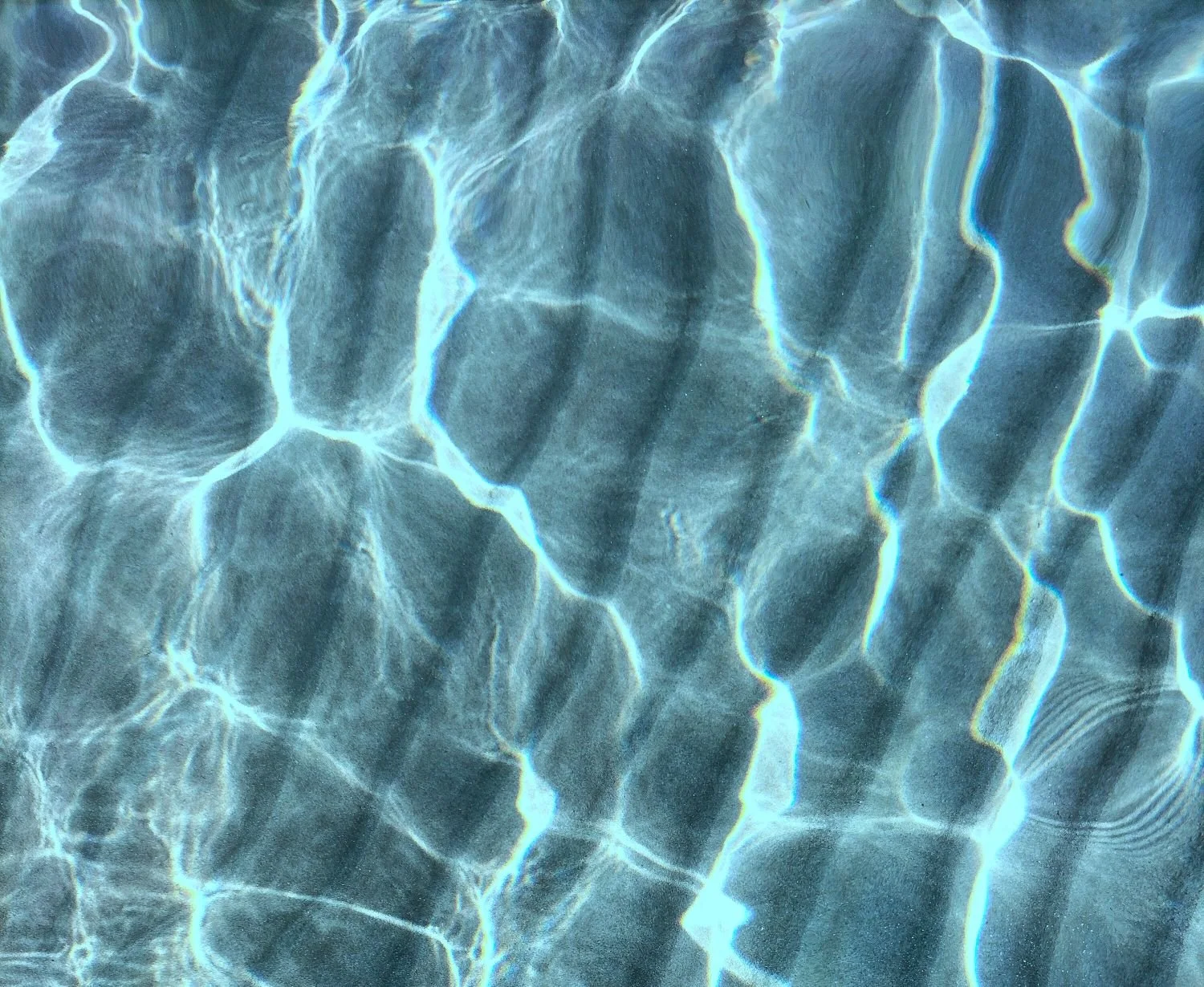 Das Bild zeigt Wasser mit Lichtreflexionen, die komplexe Muster auf der Wasseroberfläche bilden.