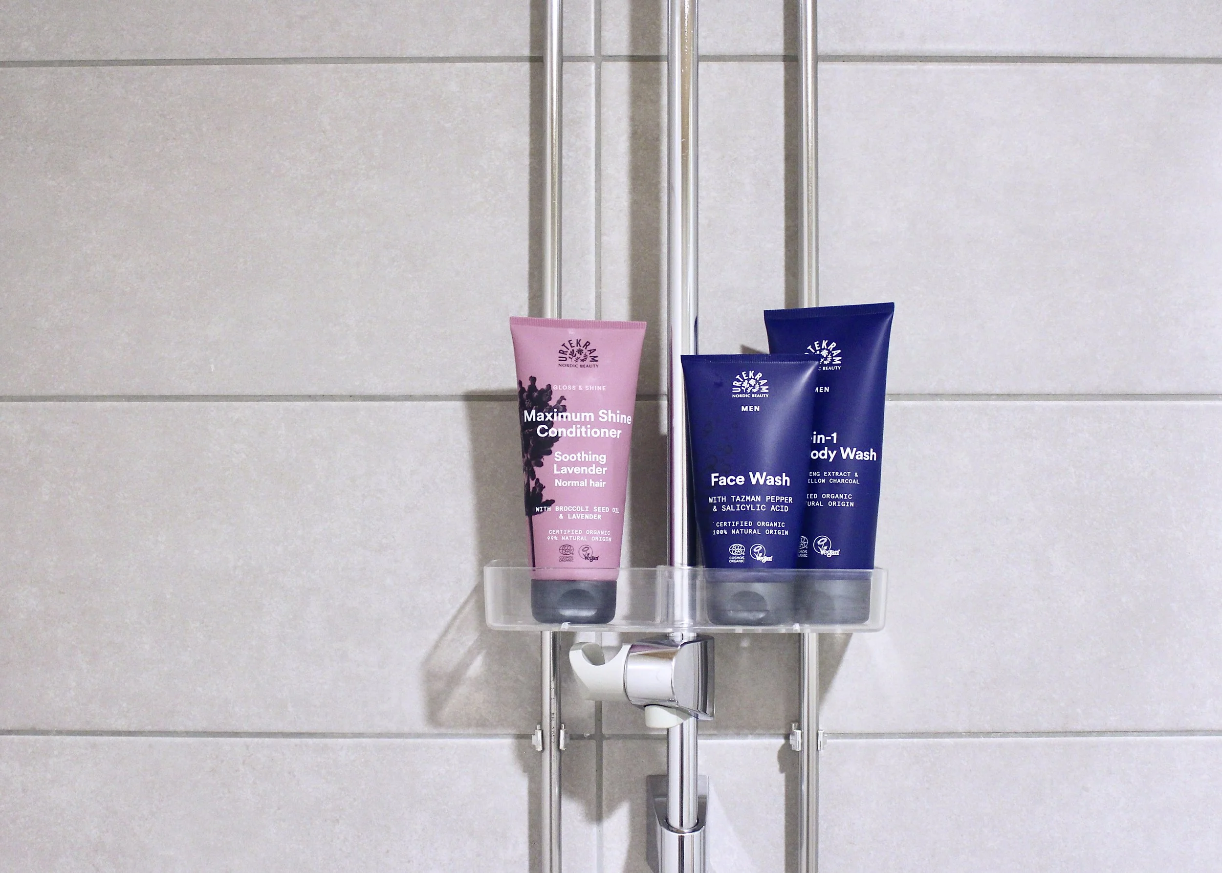 Kuva suihkuhyllystä, jossa kolme saippuatuubia.