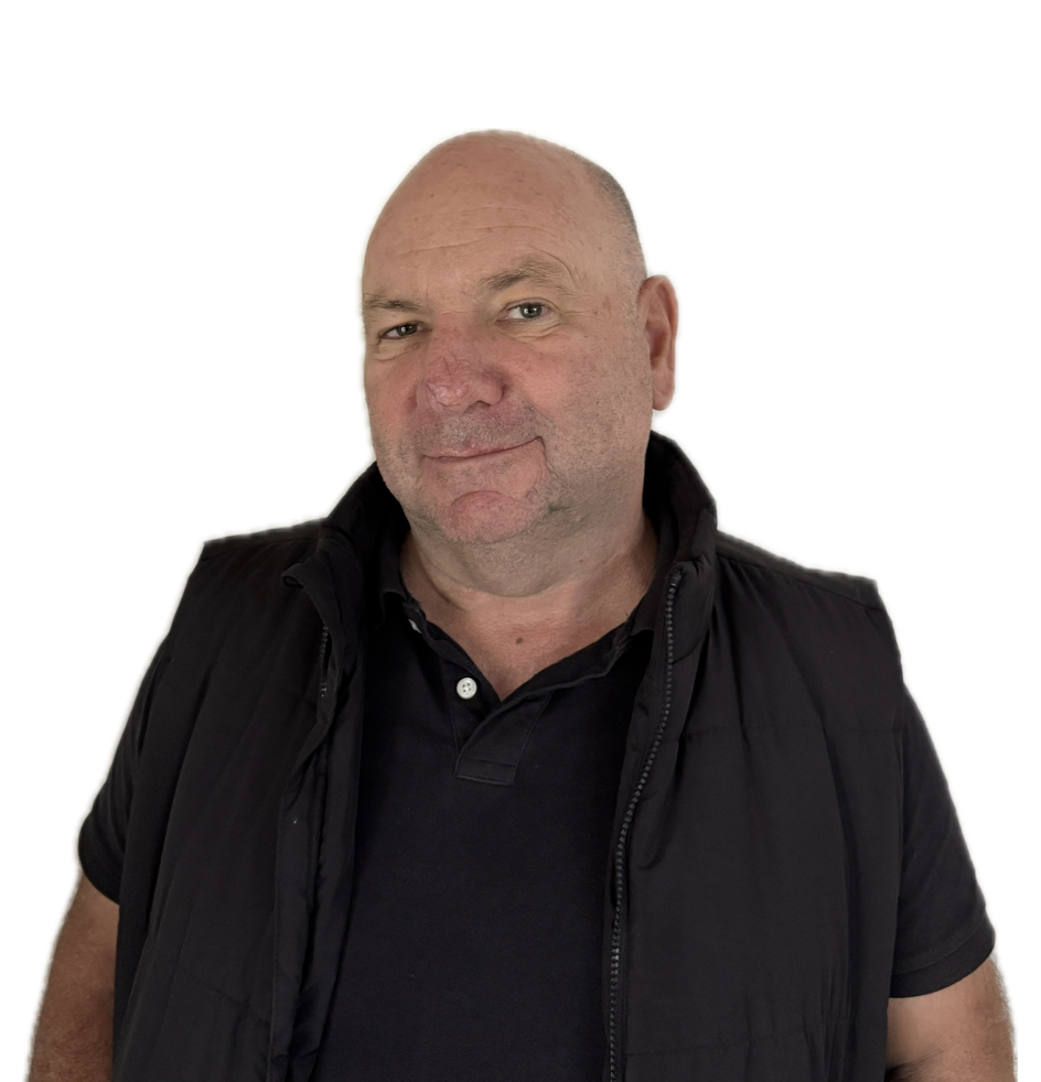 A middle-aged man with a bald head, slight beard, and casual black clothing looks directly at the camera with a neutral expression against a plain white background.