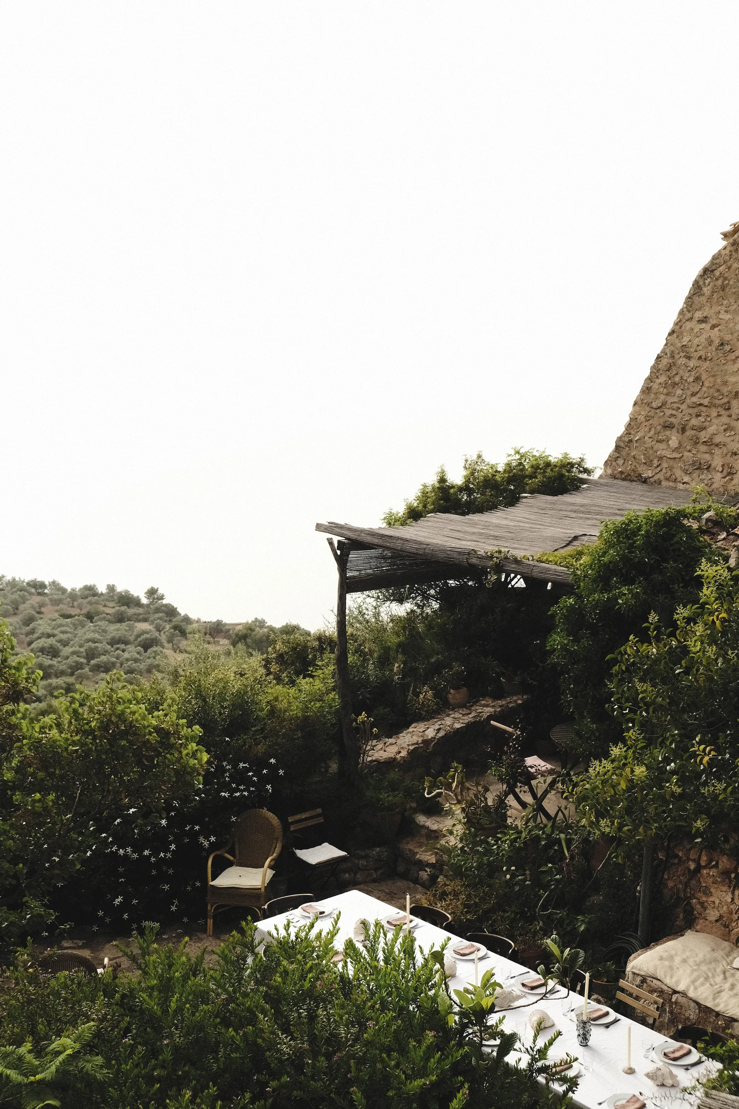 women-retreat-deia-garden-dinner-table-stone-pergola.jpg