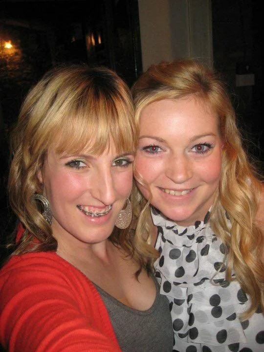 Two women taking a close-up selfie, smiling.