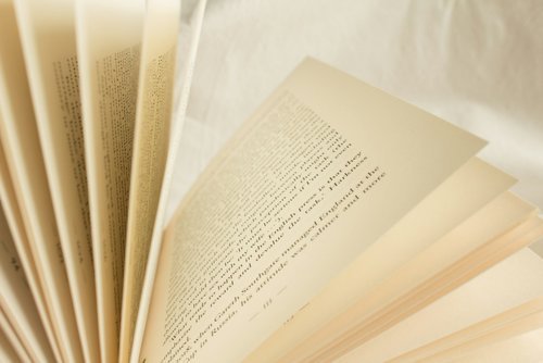 Open book with pages fanned out on a light surface.