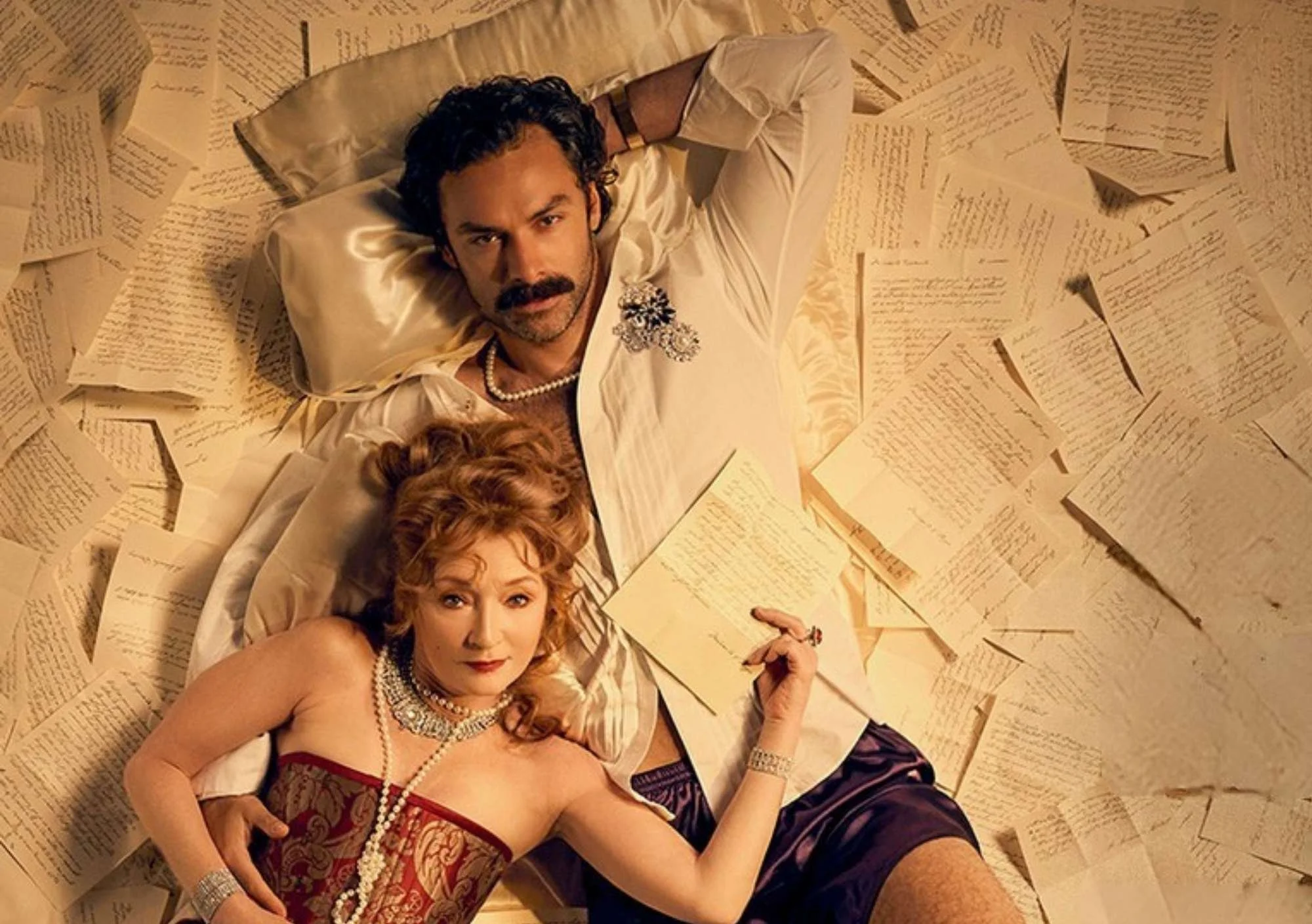 image shows man and woman laying on loose paper