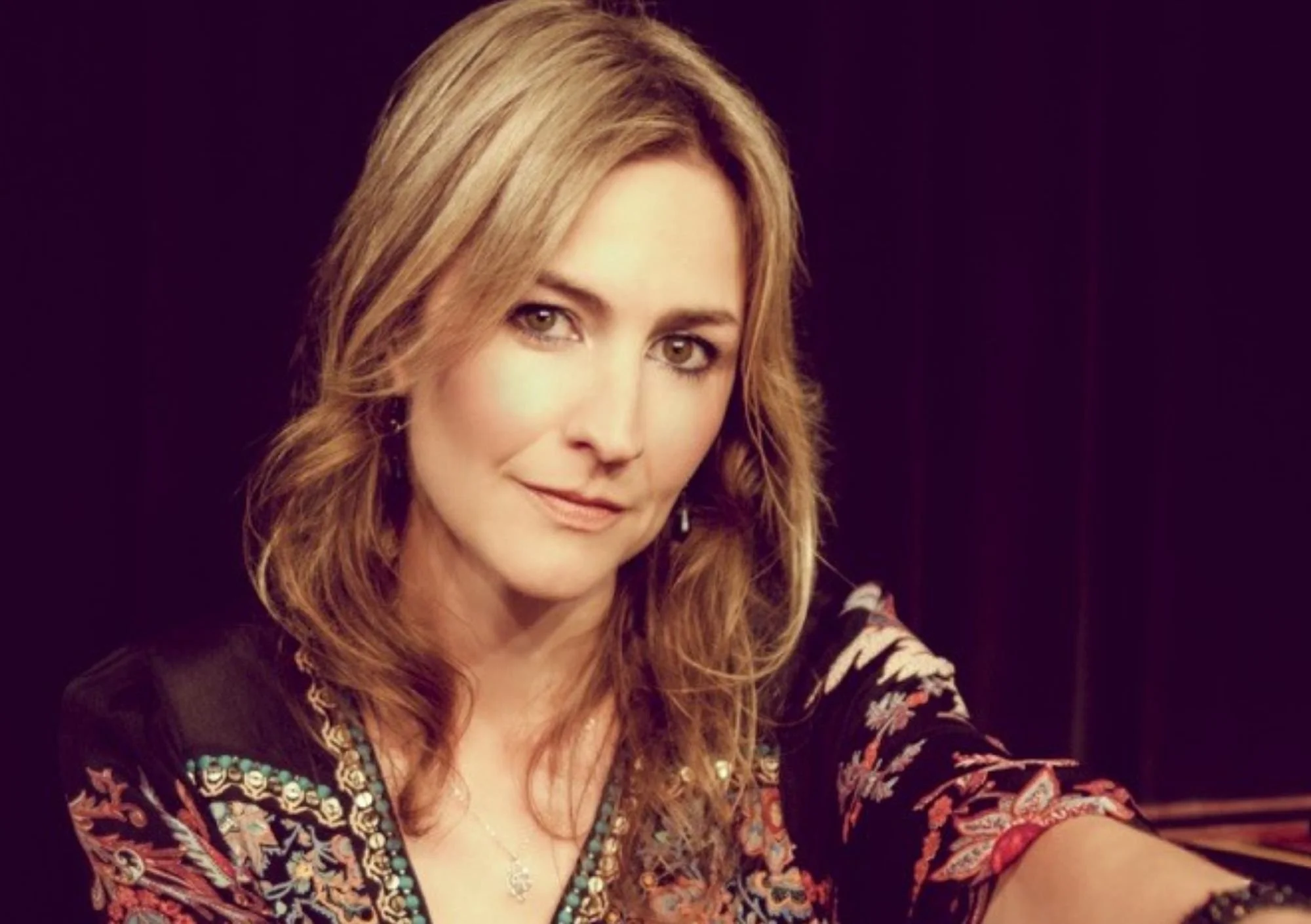 Kate Garner is looking at the camera with a black backdrop