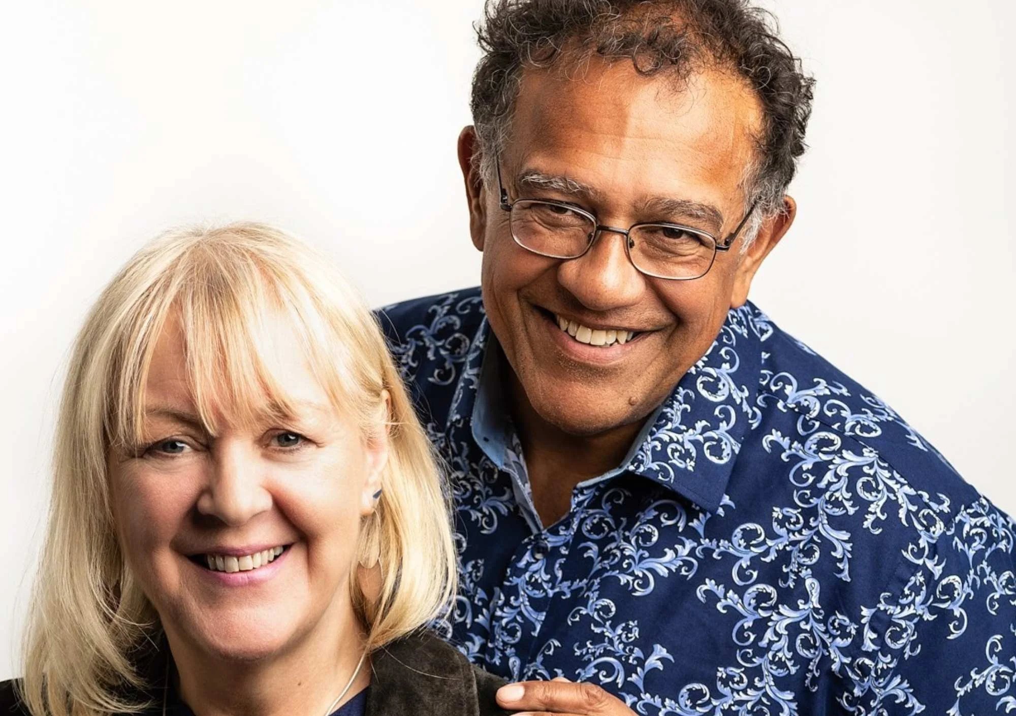 a woman and a man stand smiling at the camera