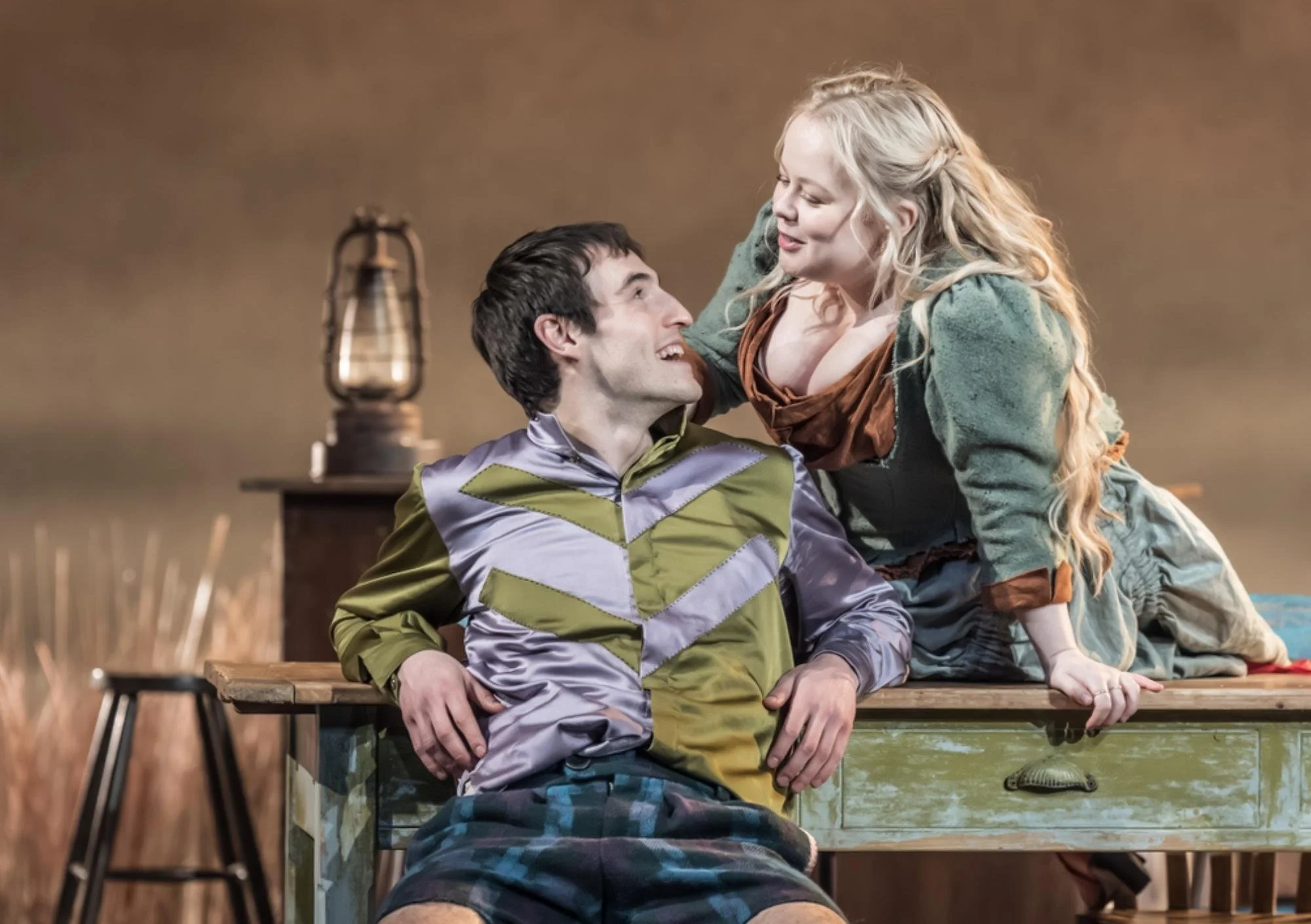 a man and a woman are looking at each other the man is sitting and the woman is to the side of him