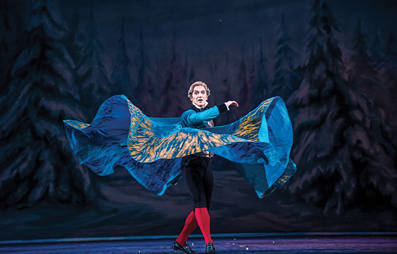 image shows man doing ballet in a blue cloak