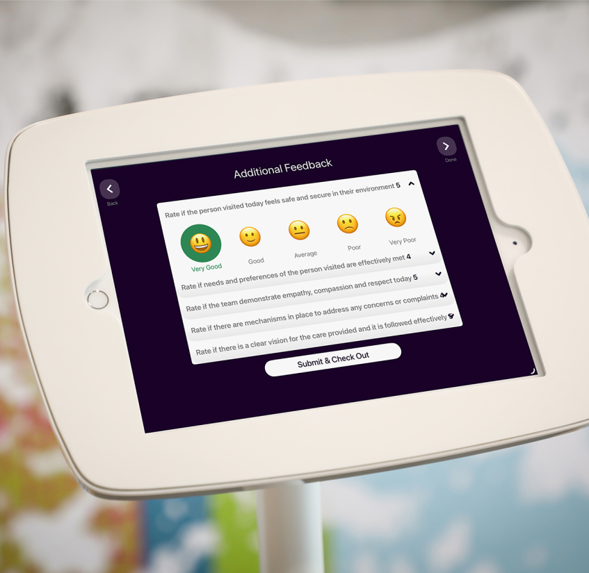 An iPad in a white stand displaying the feedback capture feature. Emojis are used to score feedback