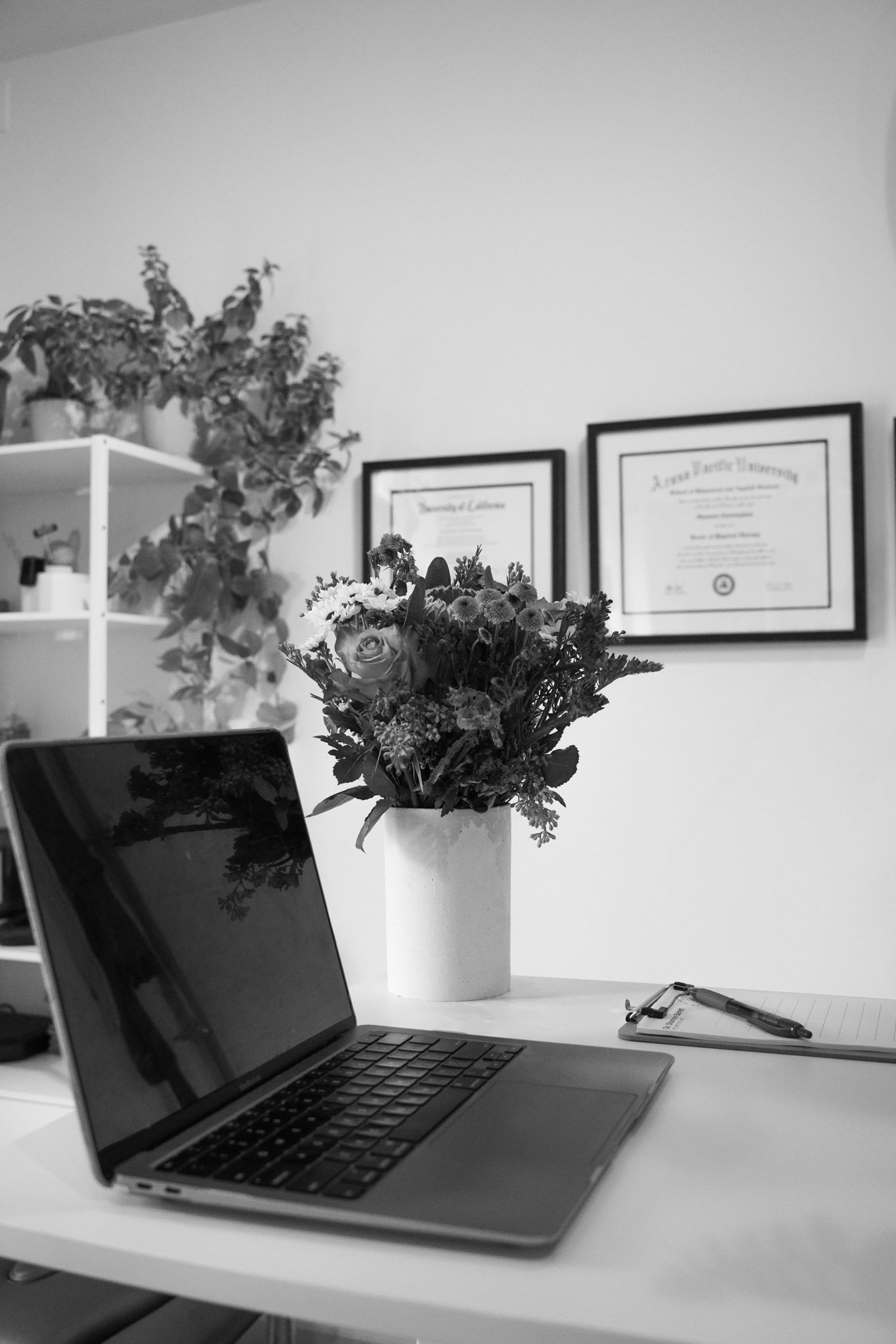 Laptop on a desk with flowers in a physical therapy office