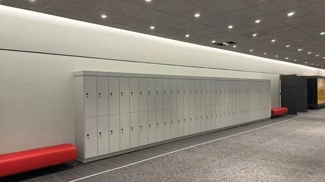A row of white lockers in an airport or public facility corridor.