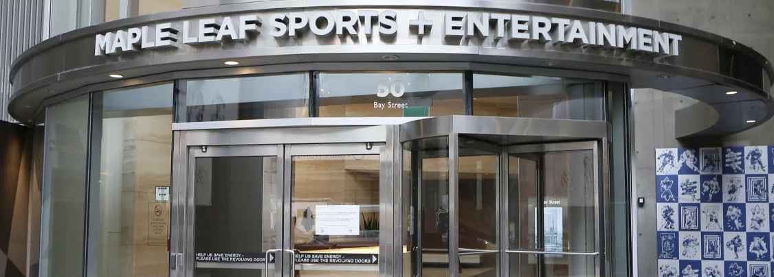 Empty white and blue metal shelving unit in an office or store, with a lockable cabinet door on the right, and a lock on the right-side panel.