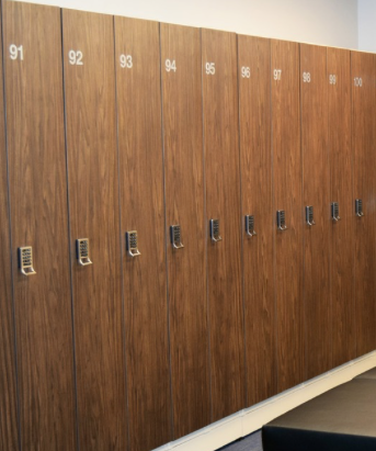 Empty store shelving unit with blue sliding doors, some white shelves, and a black handle, with a small cardboard box on the bottom shelf.