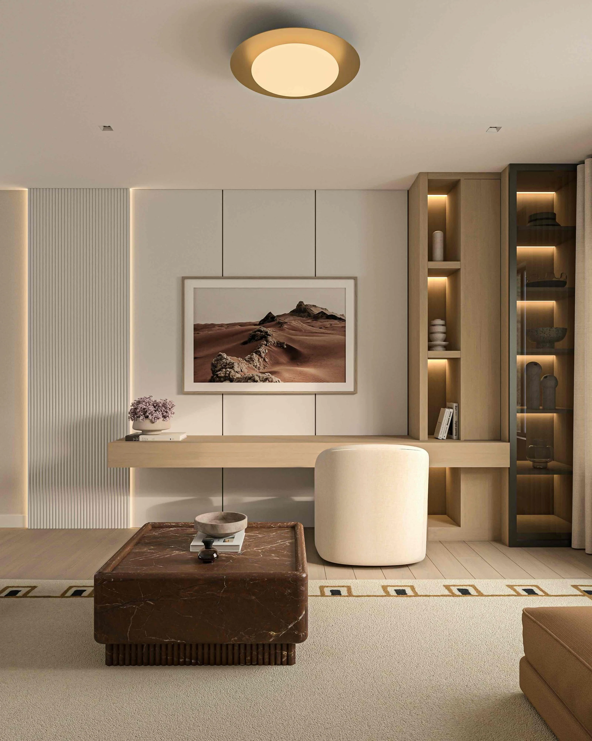 Decorative entryway with a black-framed mirror, a cream-colored console table, a brown table lamp, a small stack of books, and a white vase with dried branches, against textured beige wallpaper.