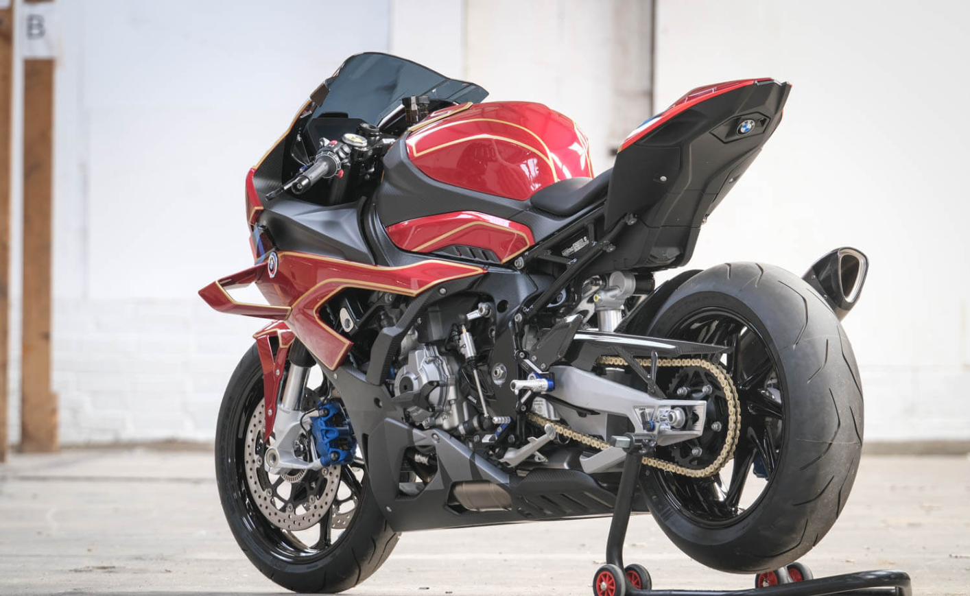 Moto sportive rouge garée dans un garage.