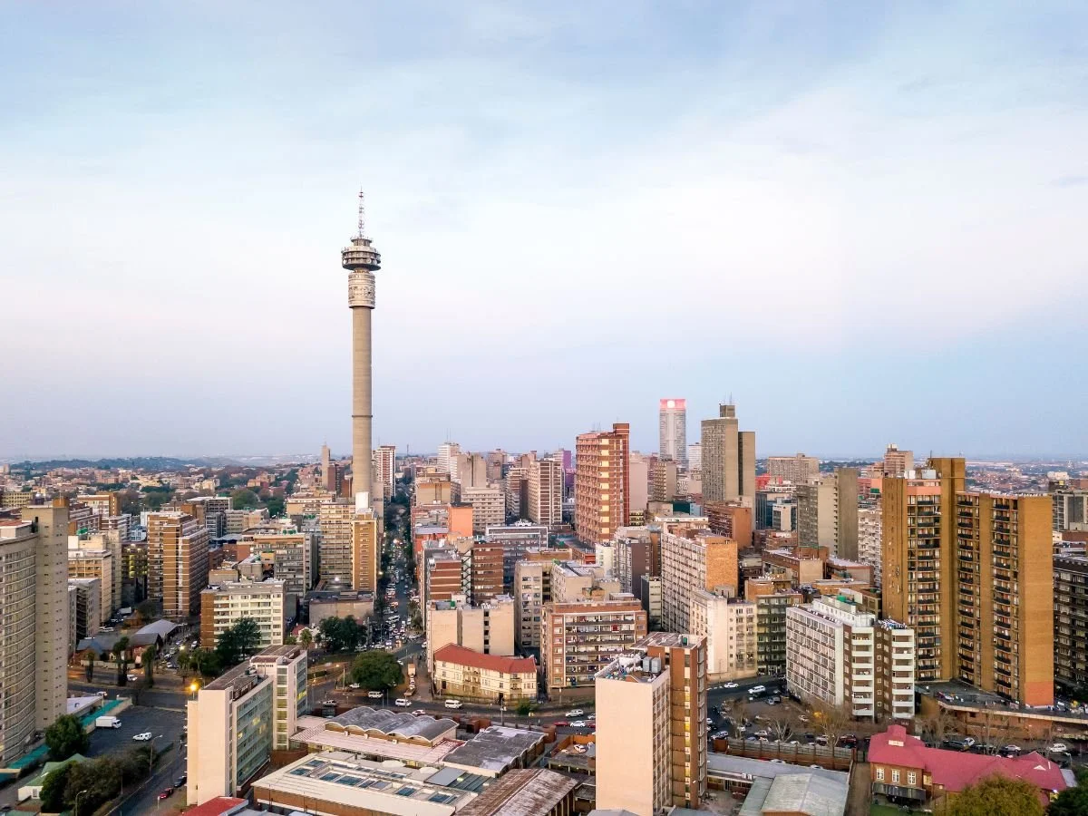 Skyline di Johannesburg al tramonto, con la torre di telecomunicazioni che svetta tra i palazzi residenziali