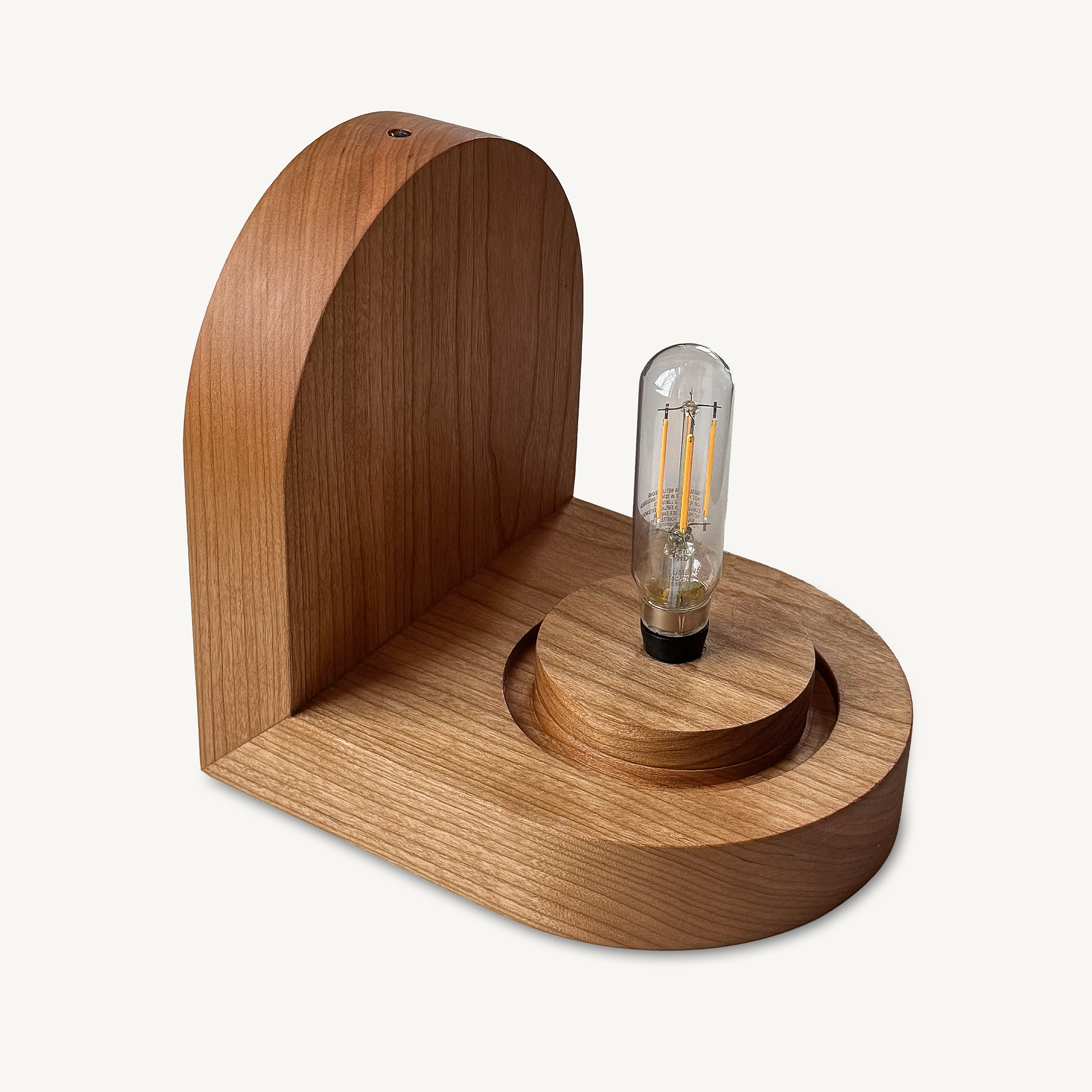 Modern, minimal wall sconce, made from solid cherry hardwood.