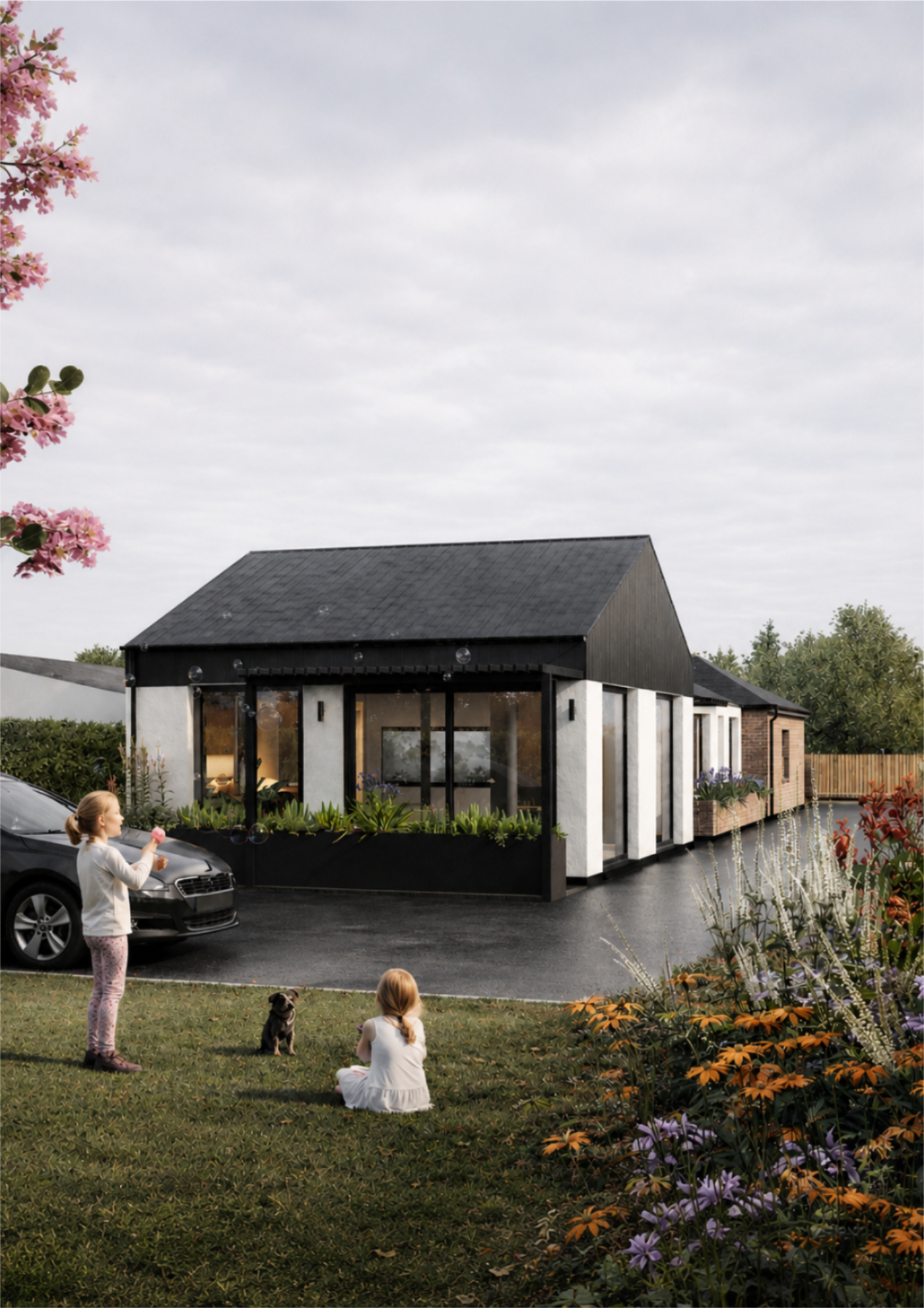A modern house with large glass windows and a black and white exterior, situated along a water, with children and a dog in the yard, flowers, and trees.