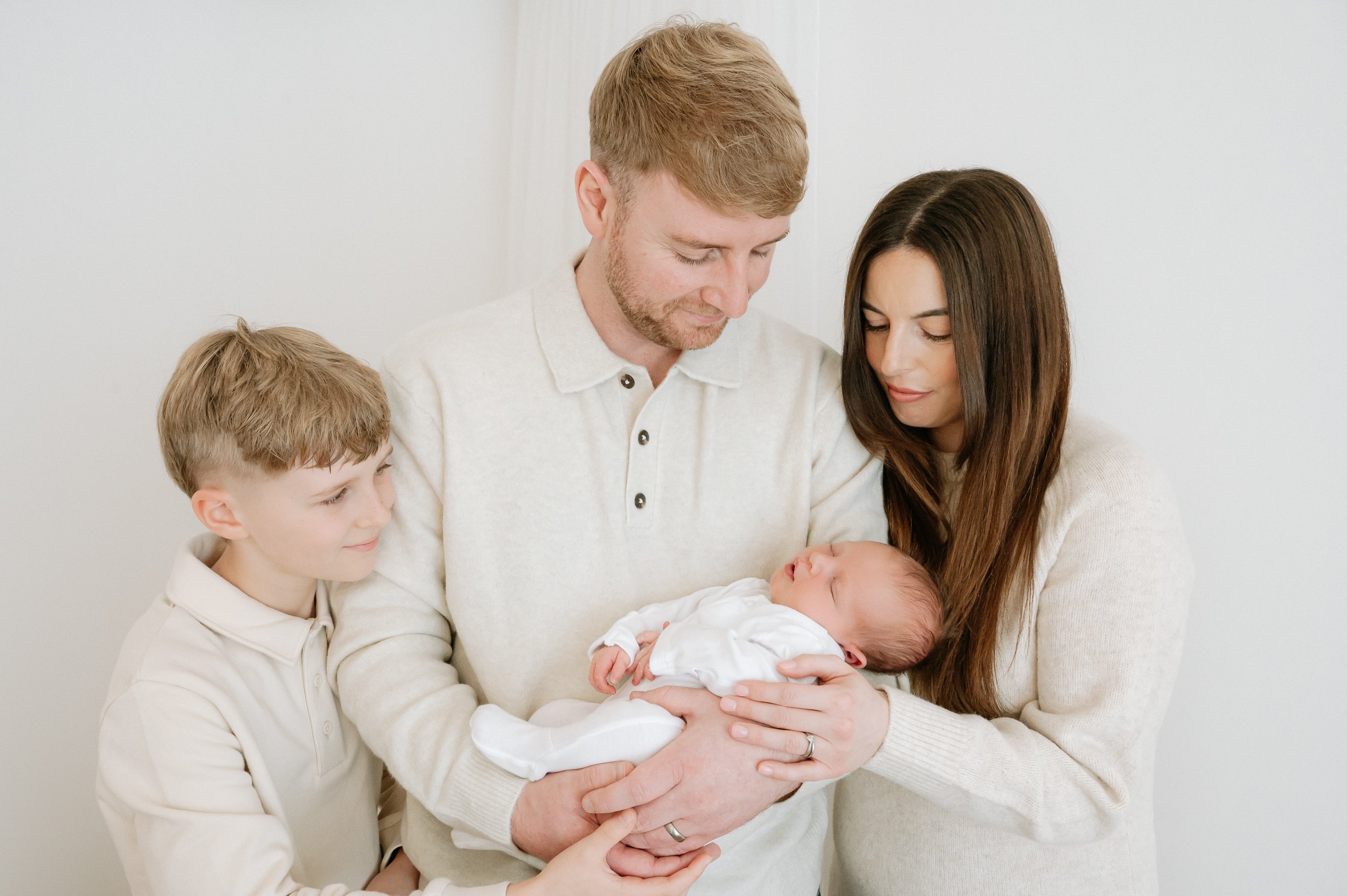 Natural family portrait of parents with their newborn baby and older sibling during a newborn photography session in Doncaster.
