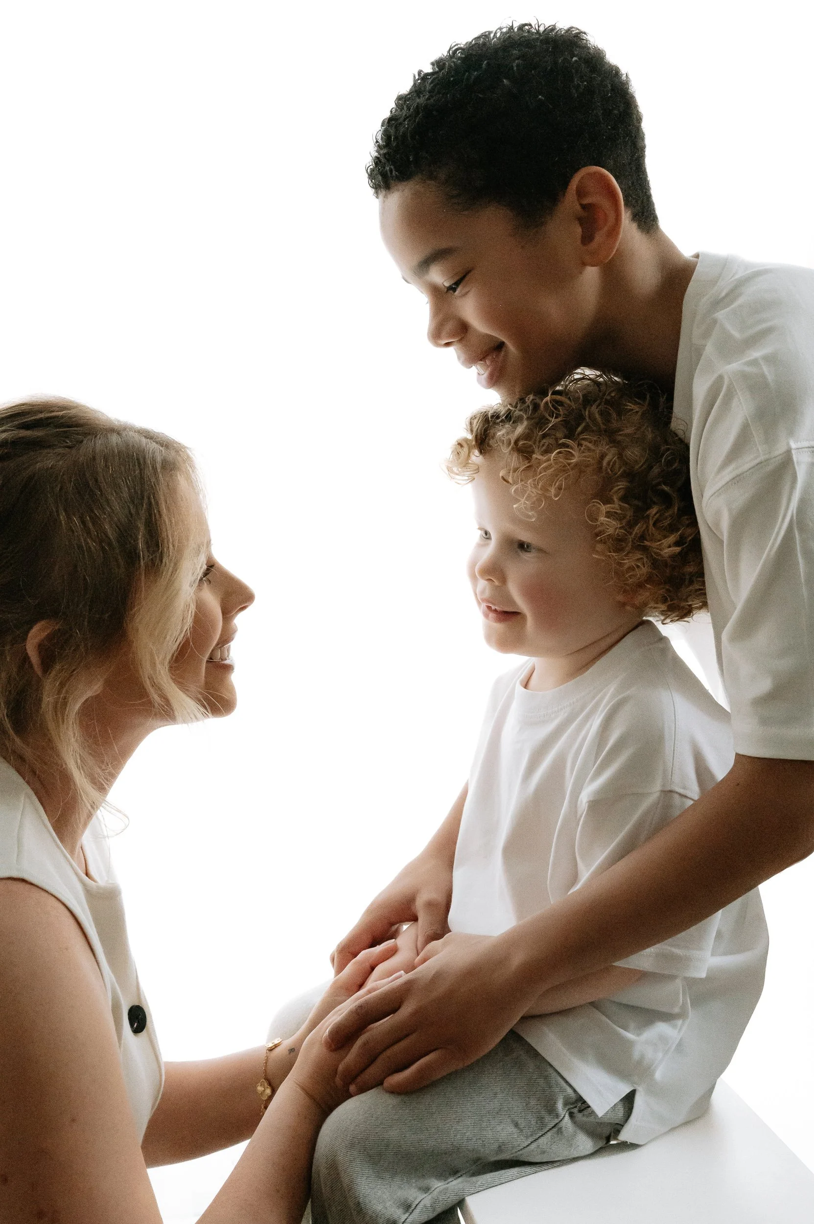 Natural family portrait of a mother sharing a special moment with her two children during a family photography session in Doncaster.