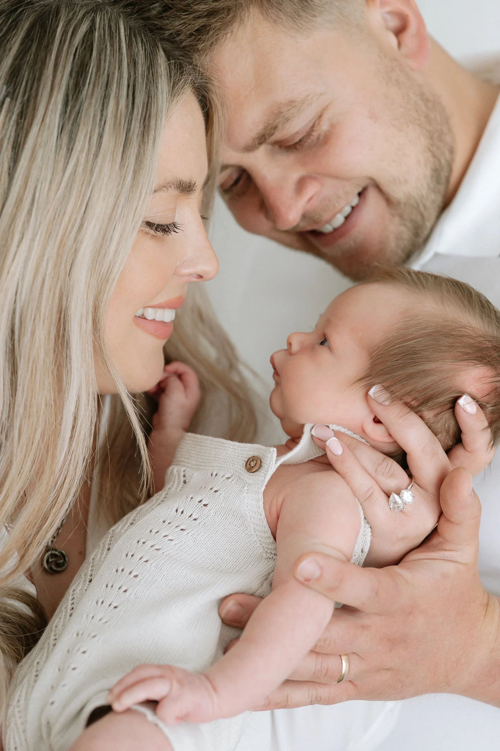 Portrait of parents lovingly holding their newborn baby during a natural light newborn photography session in Doncaster.