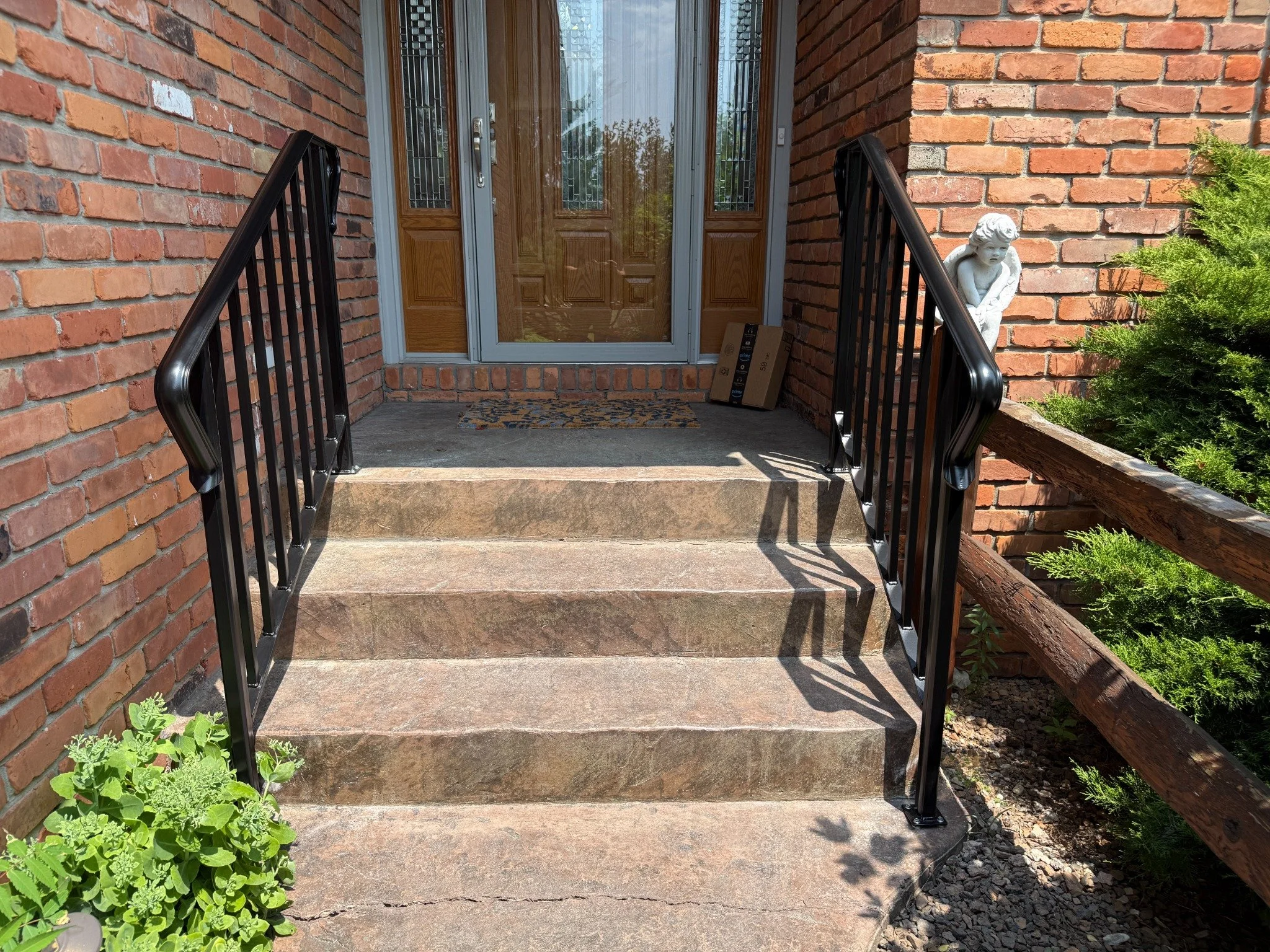Pair of finished black steel railings at a residential entry